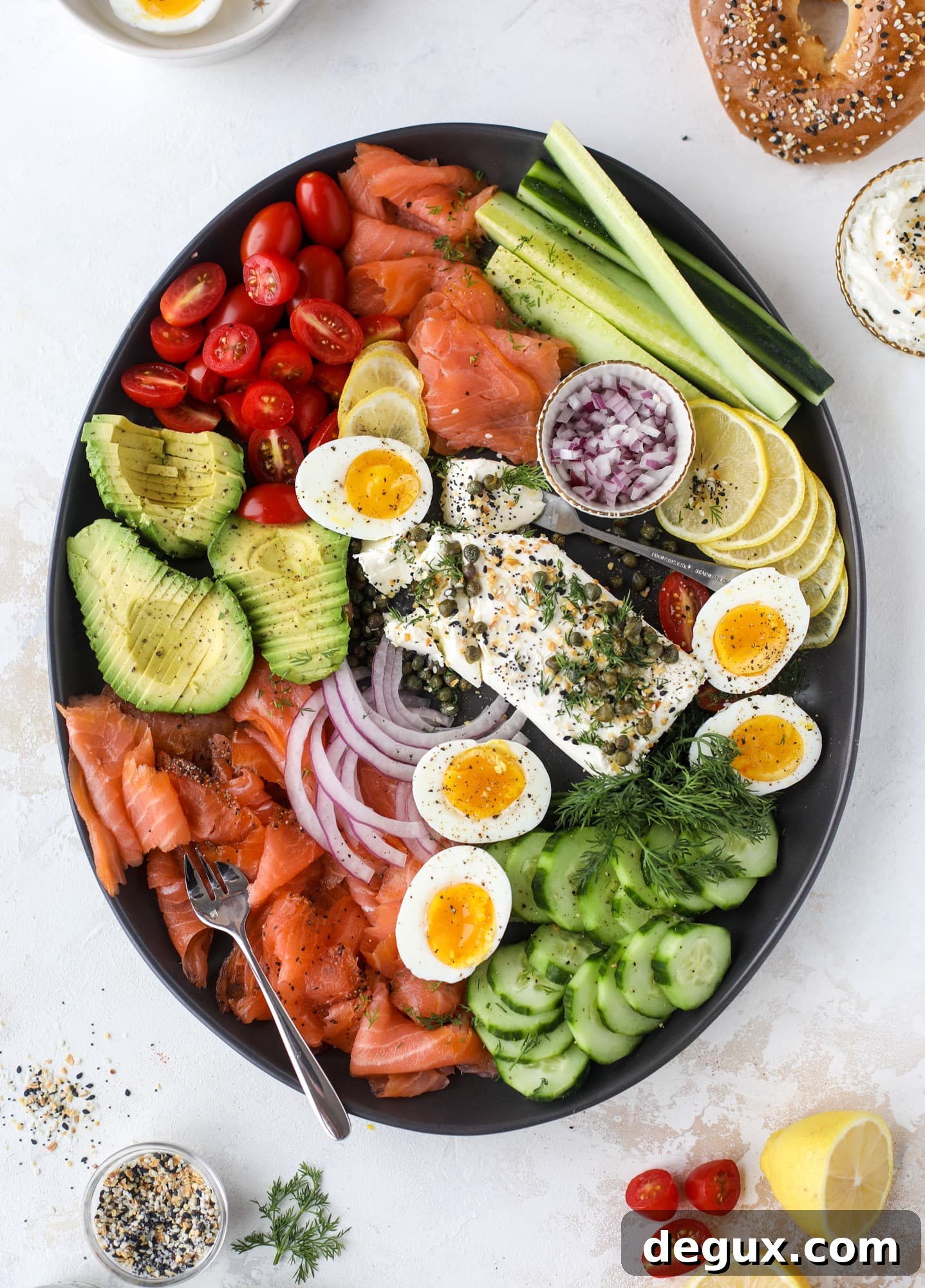 This is my favorite way to make an incredible smoked salmon platter! Fresh smoked salmon with bagels, soft boiled eggs, cream cheese and capers, everything seasoning and so much more. Perfect for holiday breakfasts and brunches! I howsweeteats.com #smokedsalmon #platter