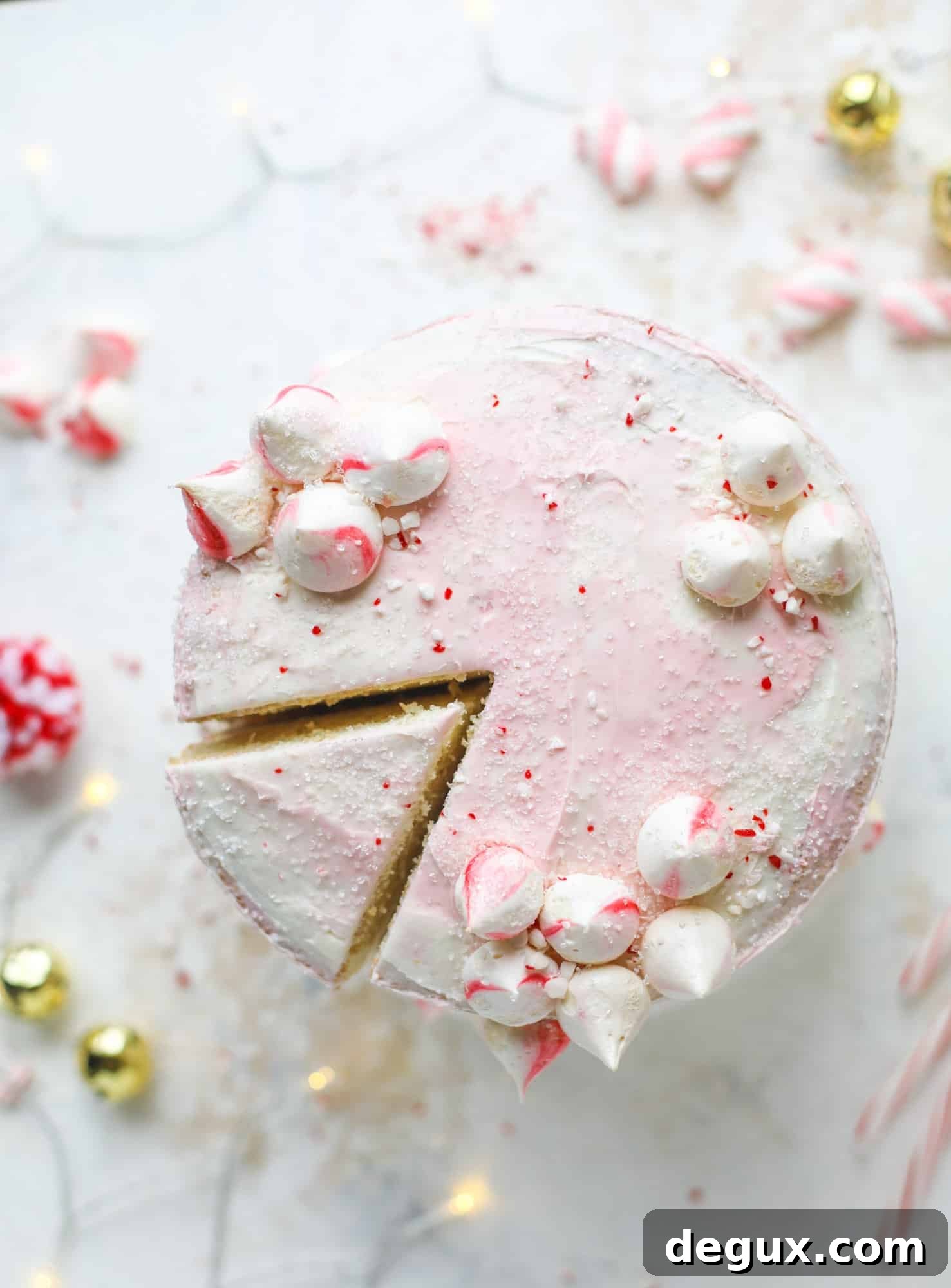 This pink peppermint cake is festive and delicious for the holidays! Layers of vanilla cake frosting with peppermint cream cheese frosting, covered in sparkly sugar and peppermint meringues. Couldn't be cuter! I #pinkpeppermint #cake