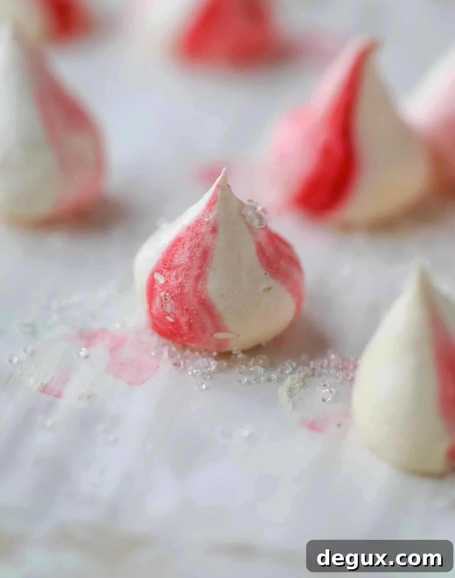 This pink peppermint cake is festive and delicious for the holidays! Layers of vanilla cake frosting with peppermint cream cheese frosting, covered in sparkly sugar and peppermint meringues. Couldn't be cuter! I #pinkpeppermint #cake