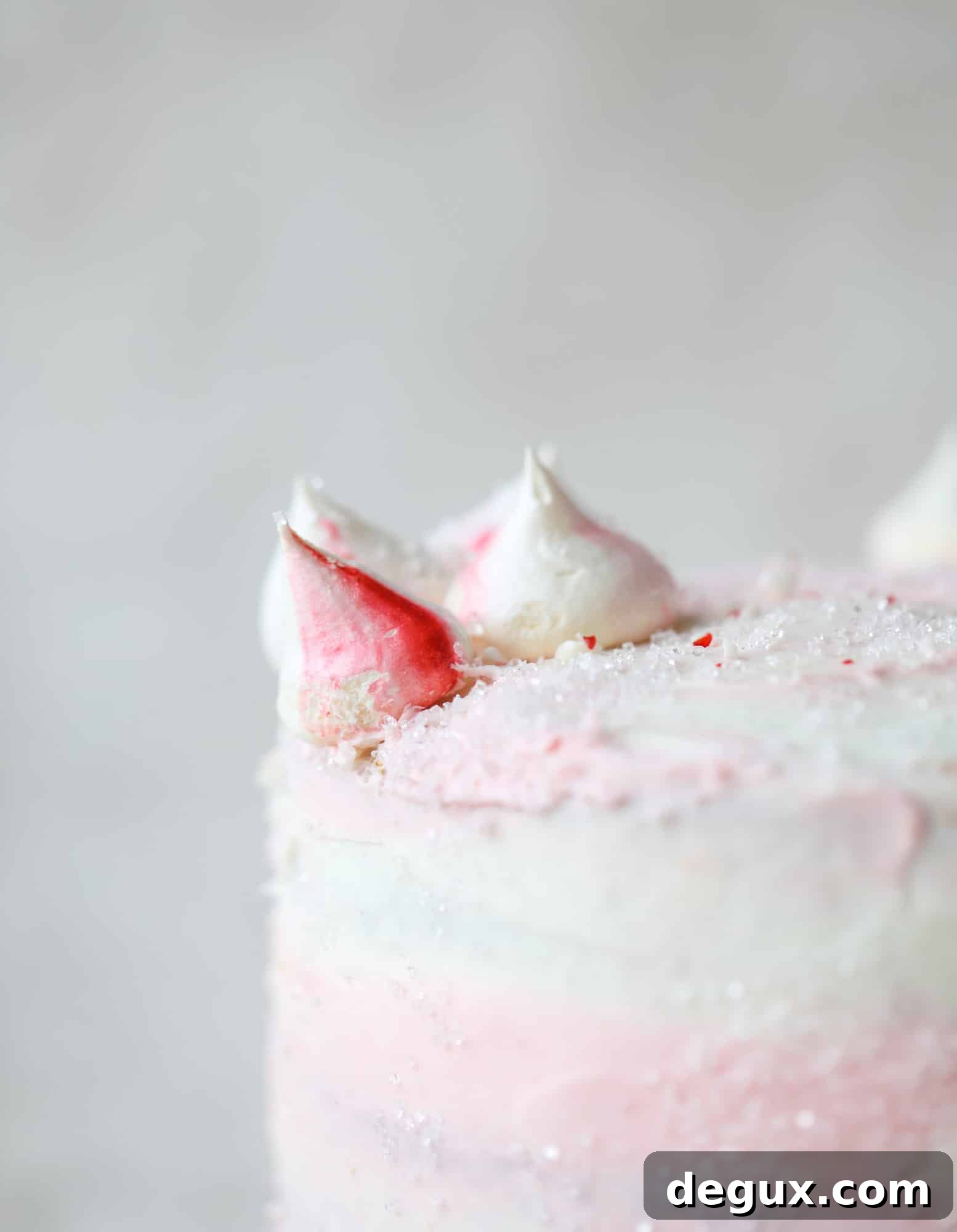 This pink peppermint cake is festive and delicious for the holidays! Layers of vanilla cake frosting with peppermint cream cheese frosting, covered in sparkly sugar and peppermint meringues. Couldn't be cuter! I #pinkpeppermint #cake