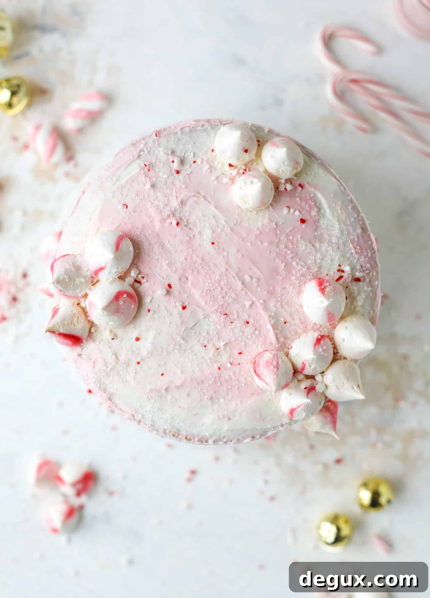 This pink peppermint cake is festive and delicious for the holidays! Layers of vanilla cake frosting with peppermint cream cheese frosting, covered in sparkly sugar and peppermint meringues. Couldn't be cuter! I #pinkpeppermint #cake