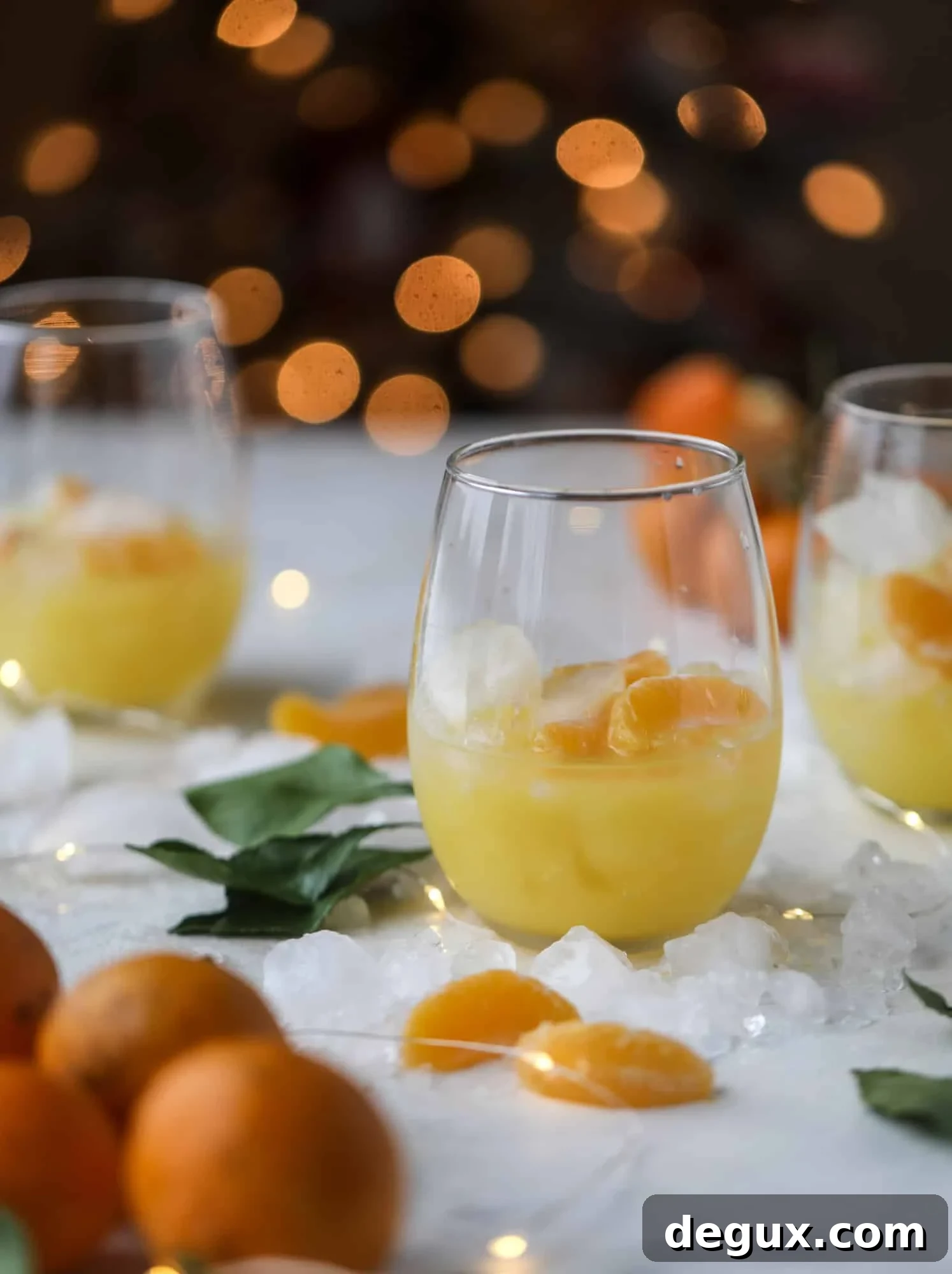 This satsuma cocktail is perfect for the holiday season and winter months when sweet satsumas are in season! This cocktail uses gin or vodka and is topped with champagne and garnished with a few satsuma wedges. Delicious! I howsweeteats.com #satsuma #cocktail