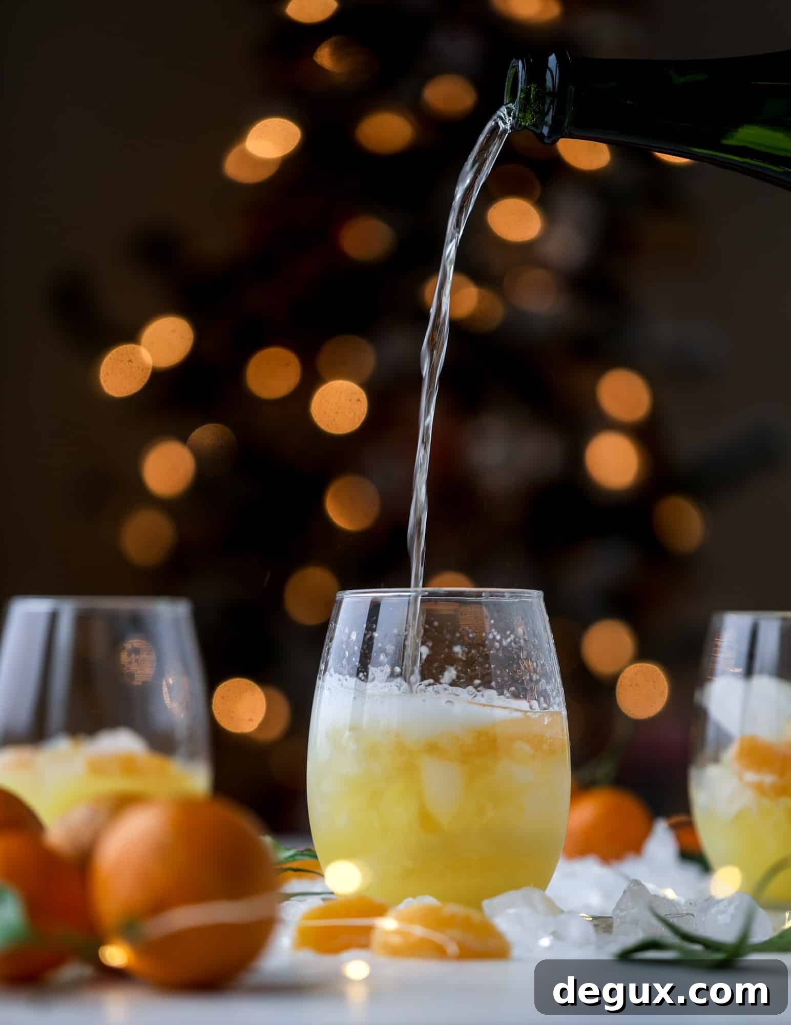 This satsuma cocktail is perfect for the holiday season and winter months when sweet satsumas are in season! This cocktail uses gin or vodka and is topped with champagne and garnished with a few satsuma wedges. Delicious! I howsweeteats.com #satsuma #cocktail