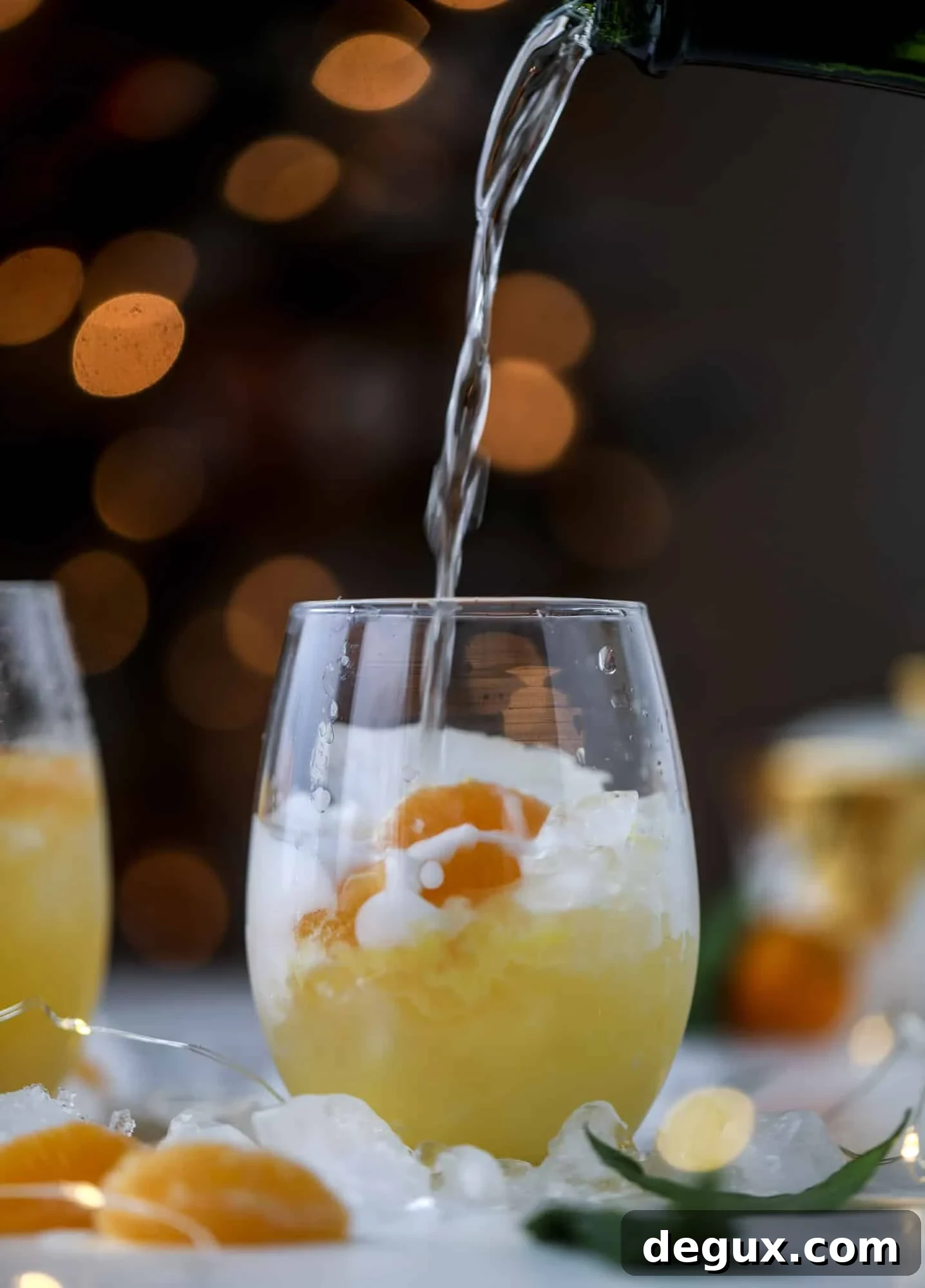 This satsuma cocktail is perfect for the holiday season and winter months when sweet satsumas are in season! This cocktail uses gin or vodka and is topped with champagne and garnished with a few satsuma wedges. Delicious! I howsweeteats.com #satsuma #cocktail