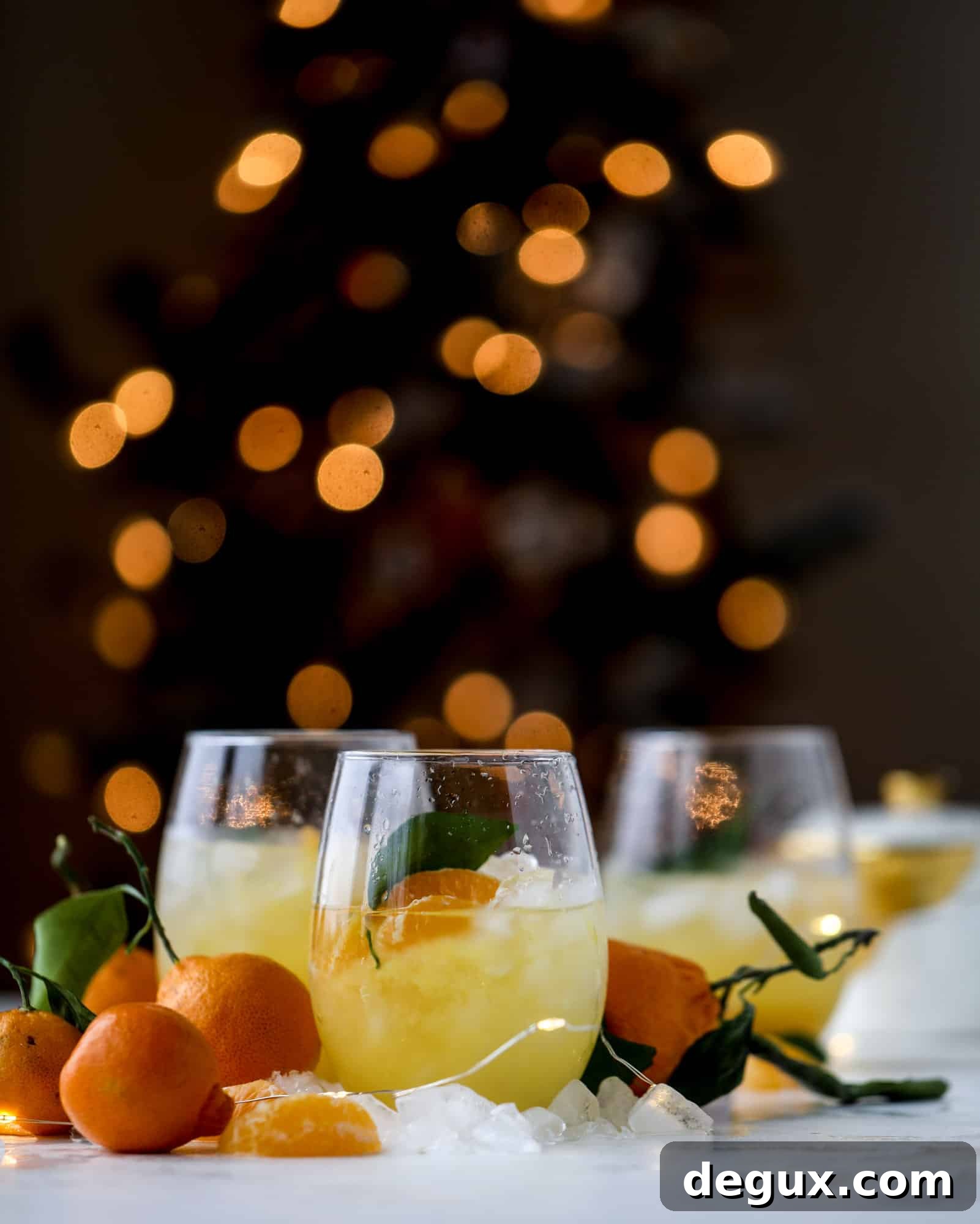 This satsuma cocktail is perfect for the holiday season and winter months when sweet satsumas are in season! This cocktail uses gin or vodka and is topped with champagne and garnished with a few satsuma wedges. Delicious! I howsweeteats.com #satsuma #cocktail
