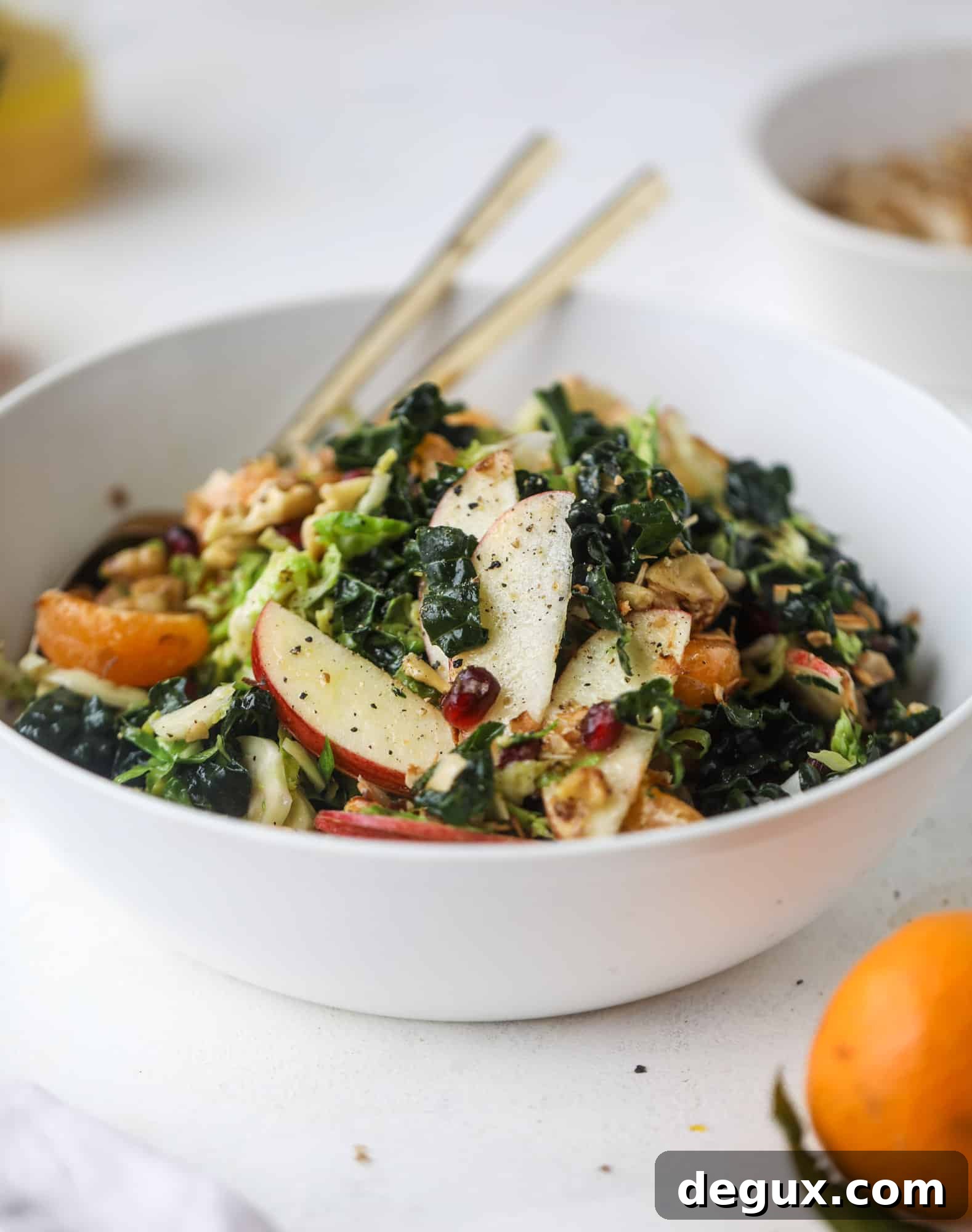 This winter crunch salad is loaded with tons of delicious, crunchy seasonal ingredients. A base of brussels sprouts and kale is topped with sliced apples, satsuma wedges, pomegranate arils, toasted walnuts and savory flaked coconut crunch. Delish! I howsweeteats.com #winter #salad