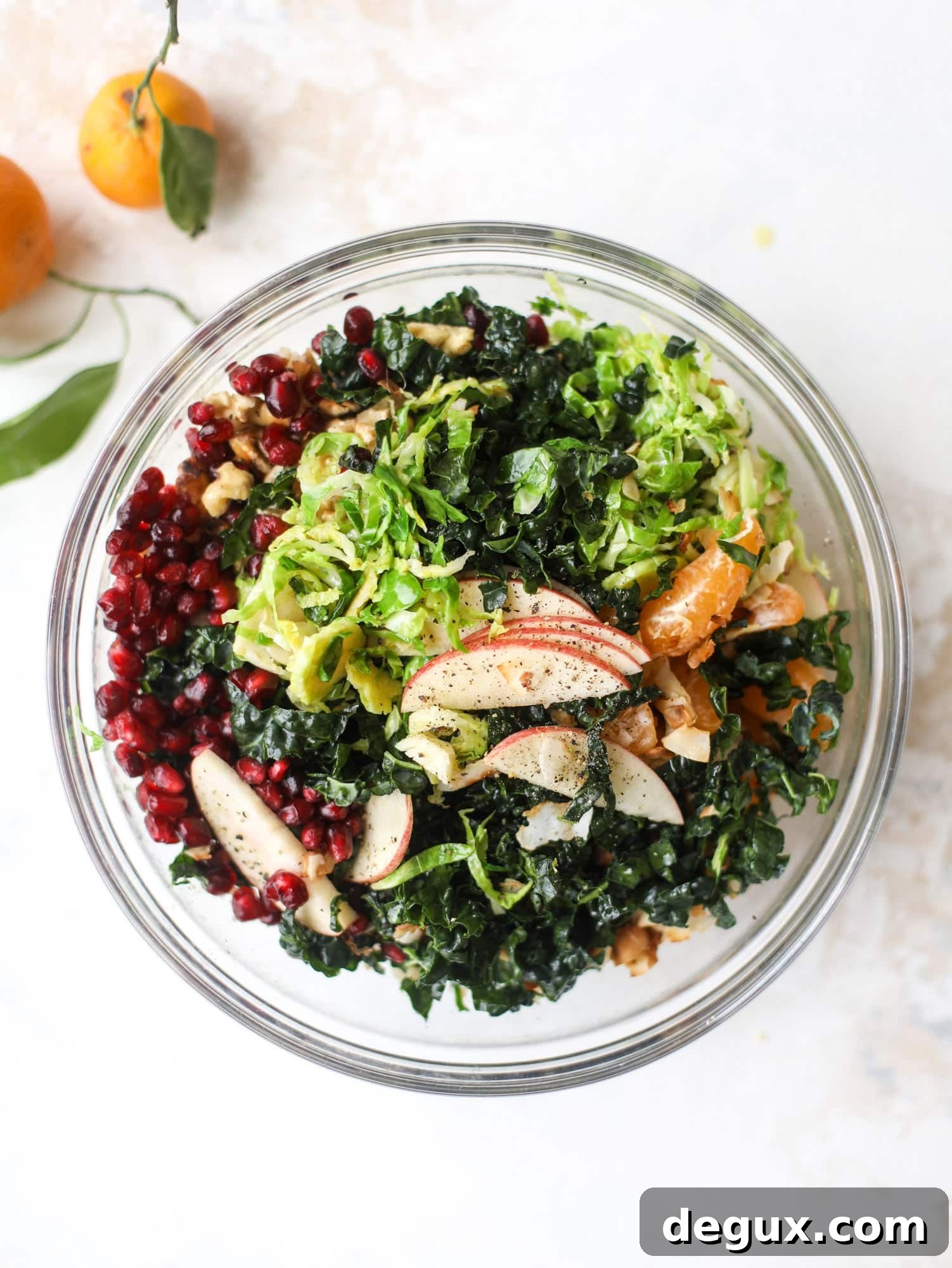 This winter crunch salad is loaded with tons of delicious, crunchy seasonal ingredients. A base of brussels sprouts and kale is topped with sliced apples, satsuma wedges, pomegranate arils, toasted walnuts and savory flaked coconut crunch. Delish! I howsweeteats.com #winter #salad