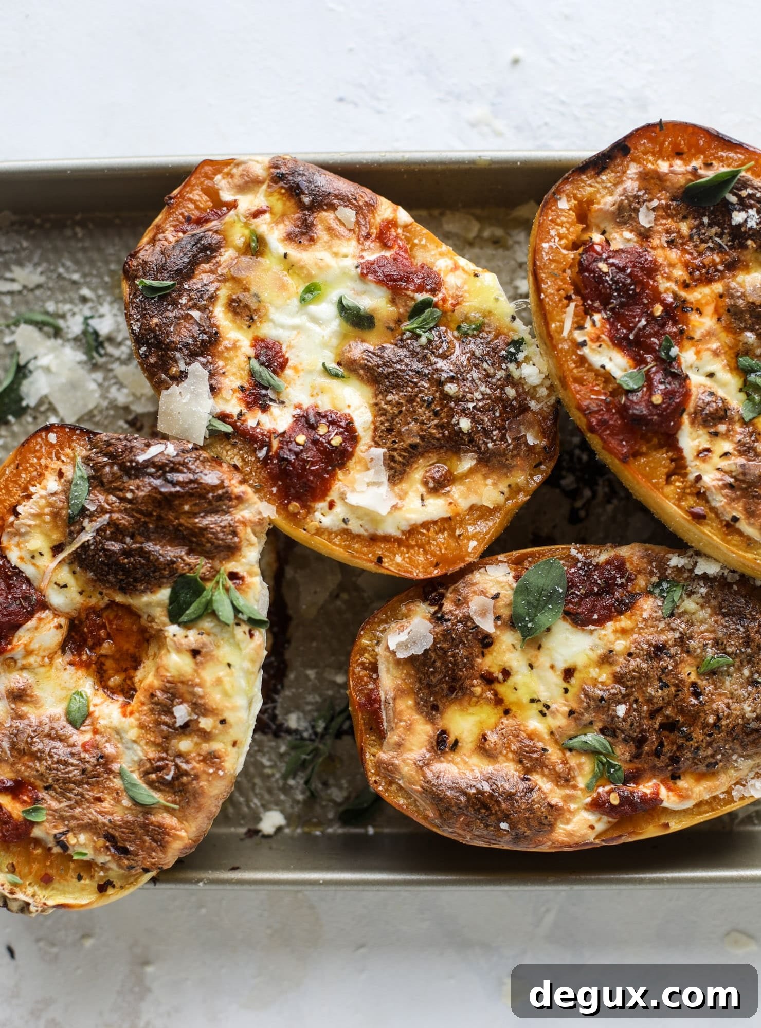 Spaghetti squash parmesan is a delicious weeknight meal! Topped with marinara or bolognese, melty cheese and fresh herbs, it's easy and delicious! I howsweeteats.com #spaghettisquash #parmesan