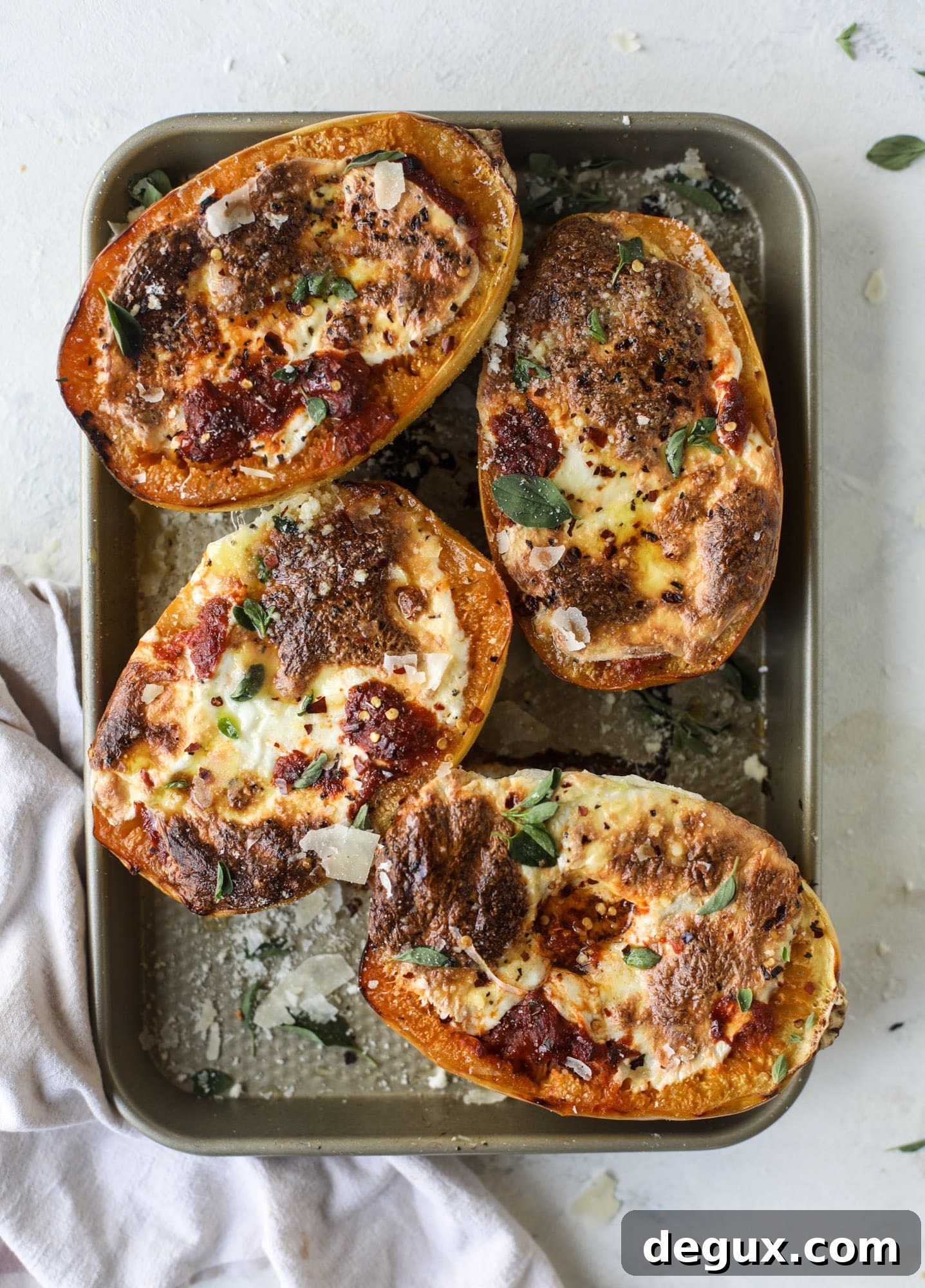 Spaghetti squash parmesan is a delicious weeknight meal! Topped with marinara or bolognese, melty cheese and fresh herbs, it's easy and delicious! I howsweeteats.com #spaghettisquash #parmesan