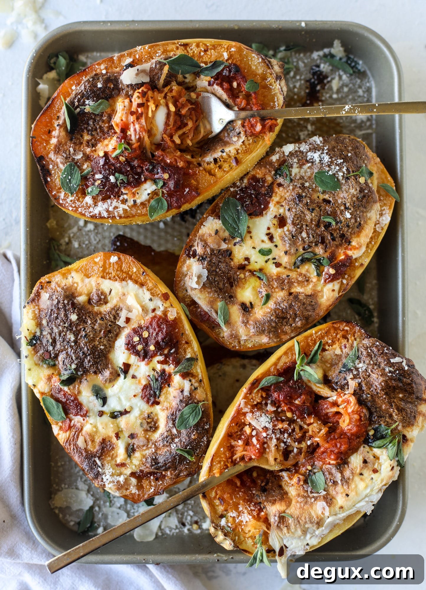 Spaghetti squash parmesan is a delicious weeknight meal! Topped with marinara or bolognese, melty cheese and fresh herbs, it's easy and delicious! I howsweeteats.com #spaghettisquash #parmesan