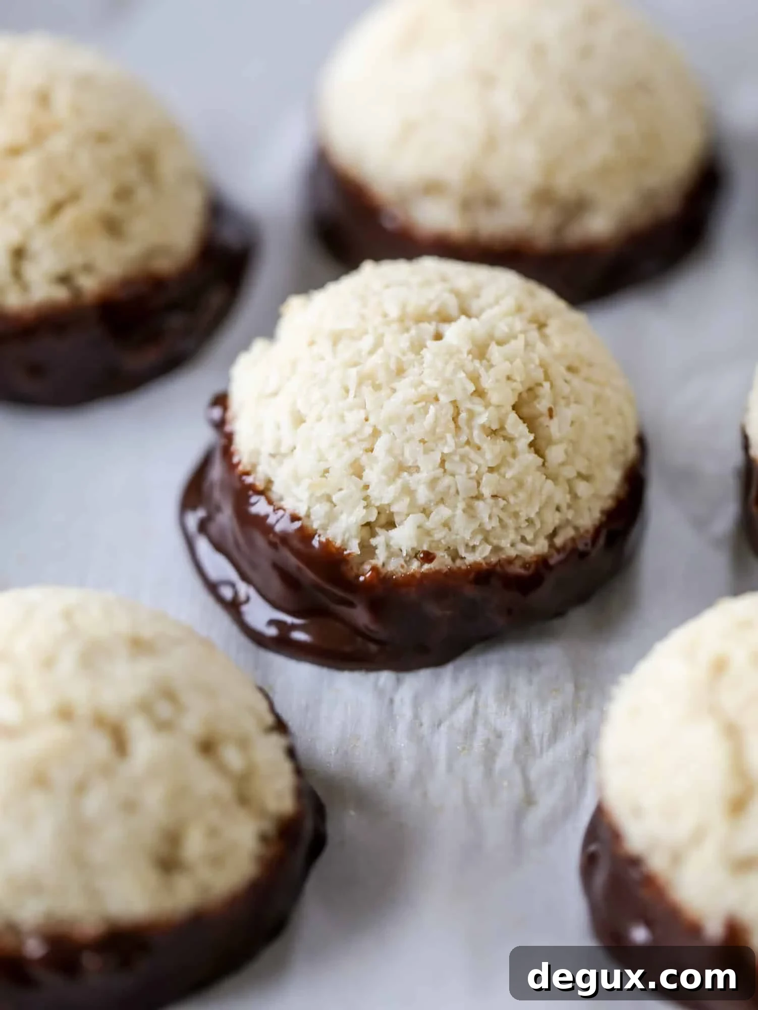 Classic chewy, slightly gooey coconut macaroons dipped in an irish cream chocolate ganache. Easy to make and gluten free too! I howsweeteats.com #irishcream #coconutmacaroons