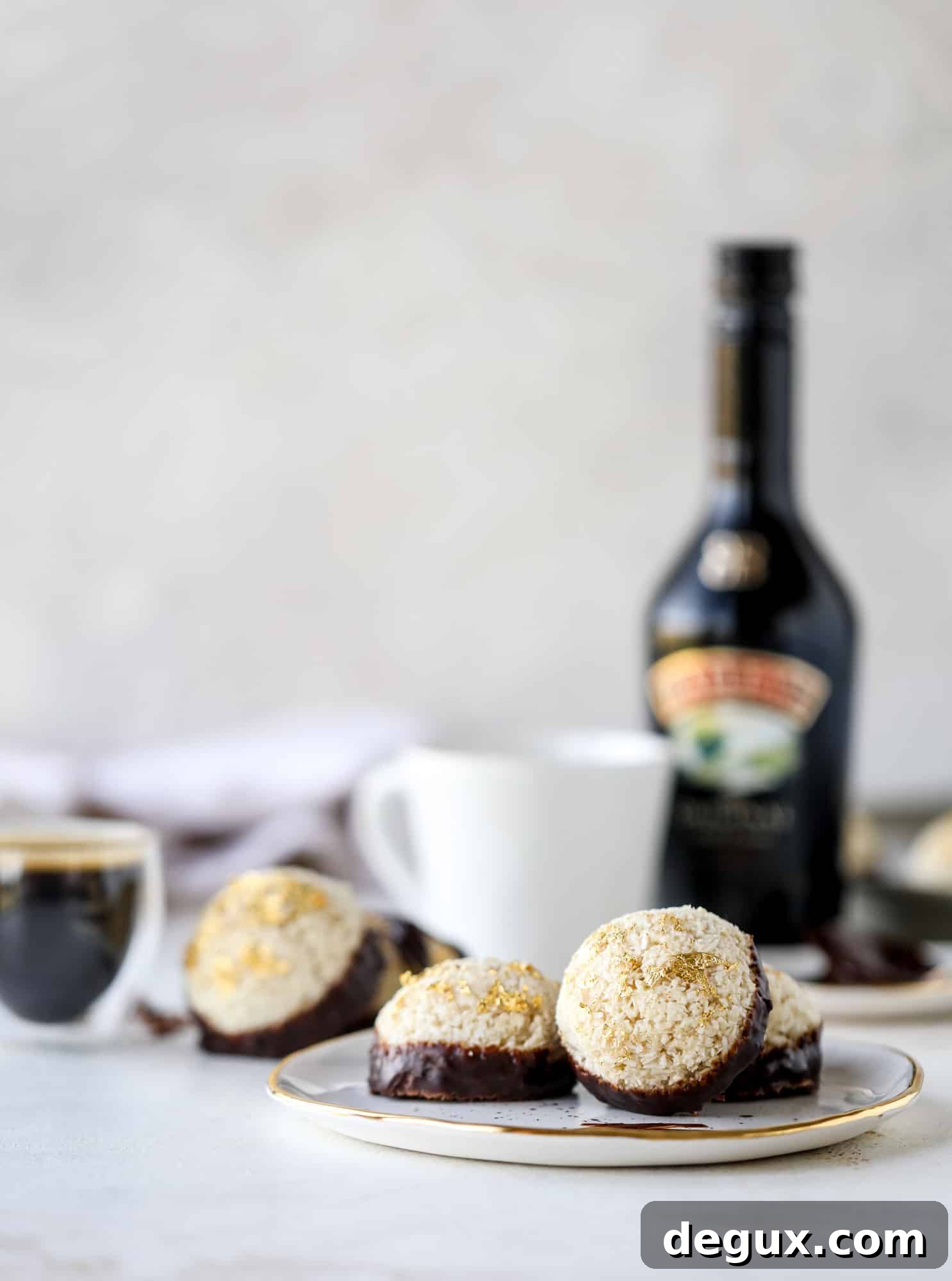 Classic chewy, slightly gooey coconut macaroons dipped in an irish cream chocolate ganache. Easy to make and gluten free too! I howsweeteats.com #irishcream #coconutmacaroons