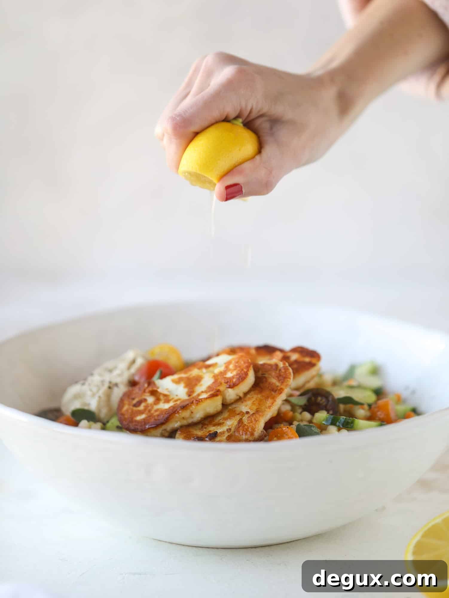 I am obsessed with these haulloumi hummus bowls for lunch or dinner. Couscous, veggies, crispy halloumi cheese and hummus with lots of lemon. Yum! I howsweeteats.com #halloumi #hummus