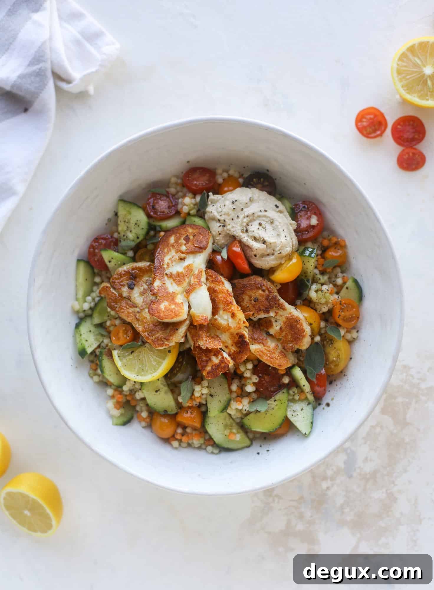 I am obsessed with these haulloumi hummus bowls for lunch or dinner. Couscous, veggies, crispy halloumi cheese and hummus with lots of lemon. Yum! I howsweeteats.com #halloumi #hummus