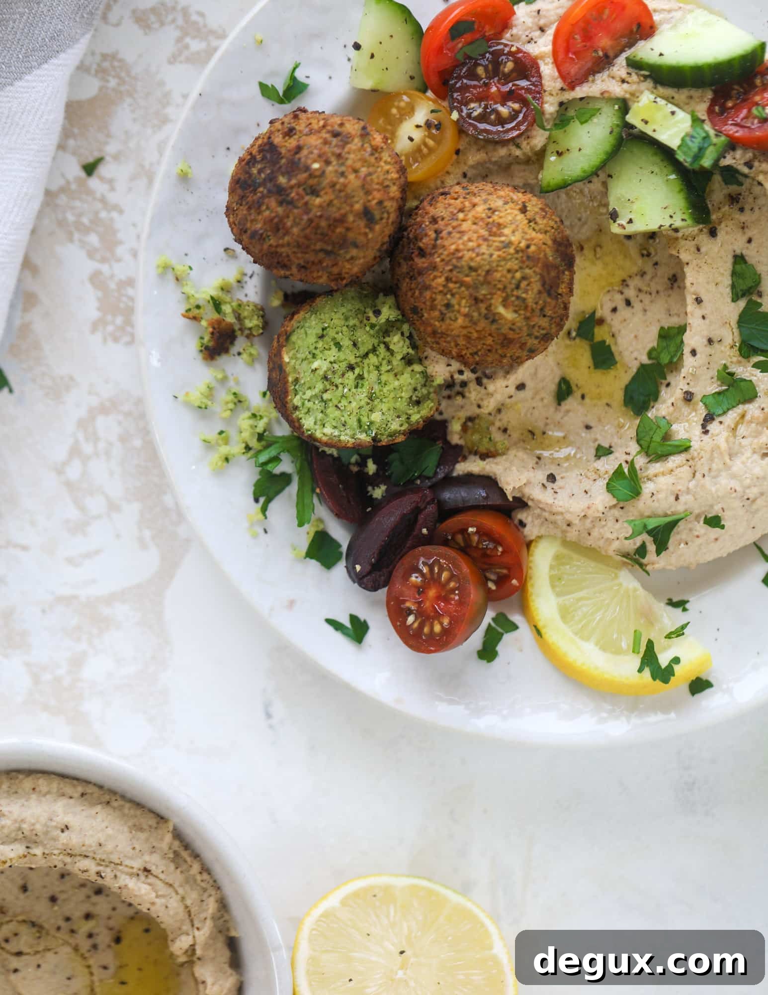 Green Goddess Falafel with Creamy Cauliflower Hummus 8 Green goddess falafel is hearty and flavorful, served over the creamiest cauliflower hummus, with tomatoes, olive, cucumbers and feta. Yum! I howsweeteats.com #falafel #cauliflowerhummus