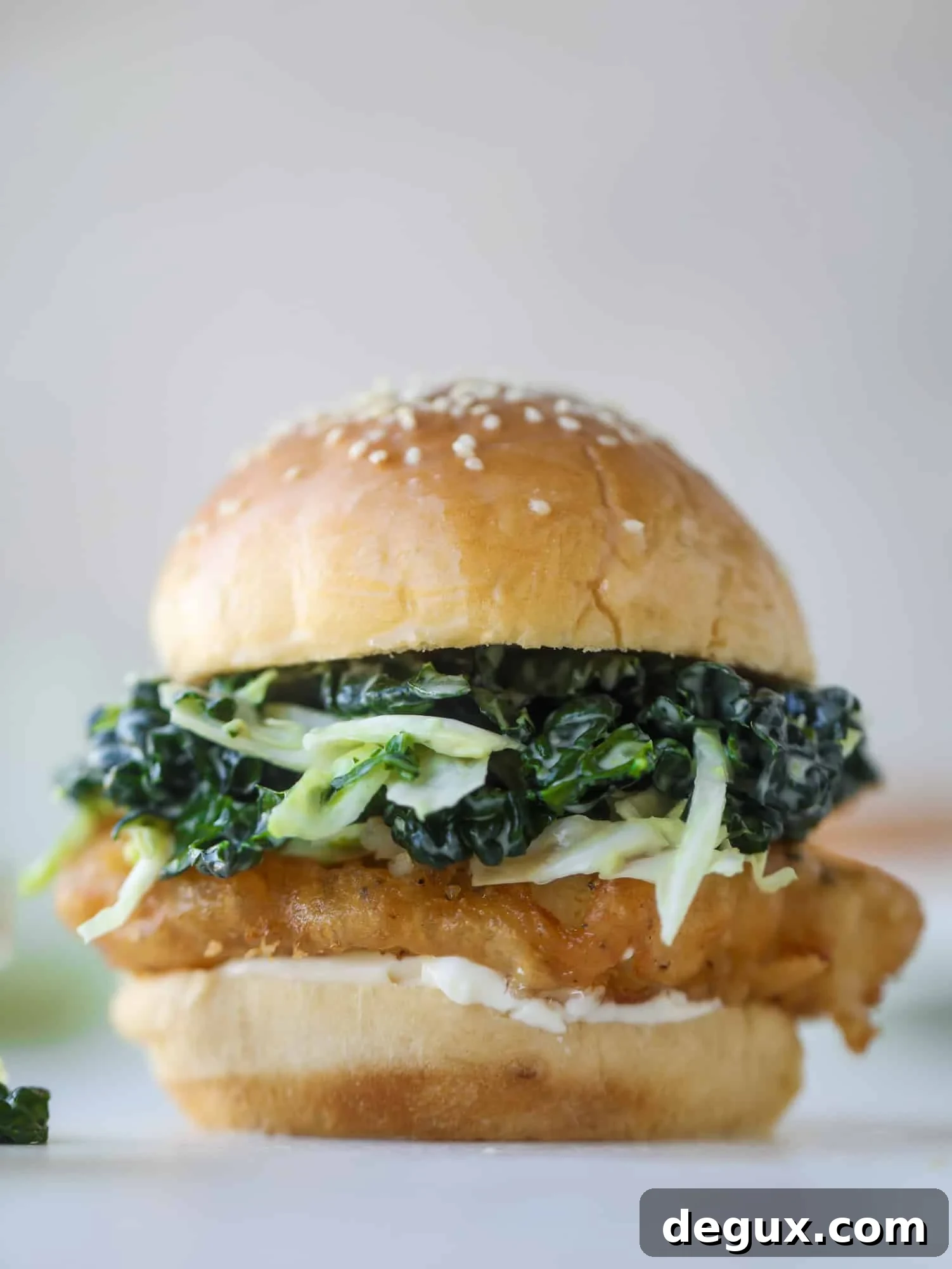Crispy Fish Sandwich with Kale Coleslaw Recipe 2 A light and crispy fish sandwich made with a simple beer batter and topped with a hearty, creamy kale cole slaw. Loaded with flavor! I howsweeteats.com #crispyfish #sandwich