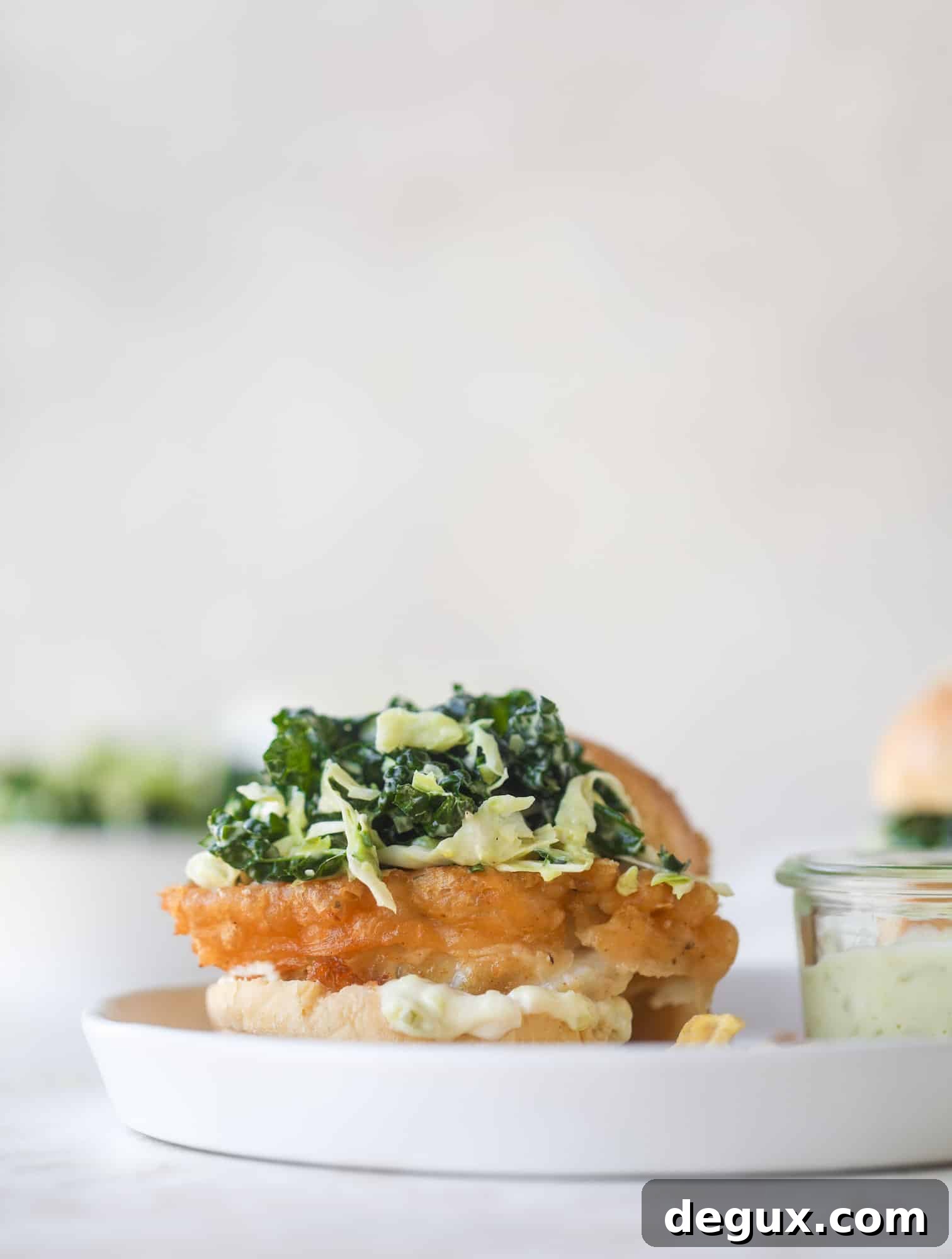 Crispy Fish Sandwich with Kale Coleslaw Recipe 8 A light and crispy fish sandwich made with a simple beer batter and topped with a hearty, creamy kale cole slaw. Loaded with flavor! I howsweeteats.com #crispyfish #sandwich
