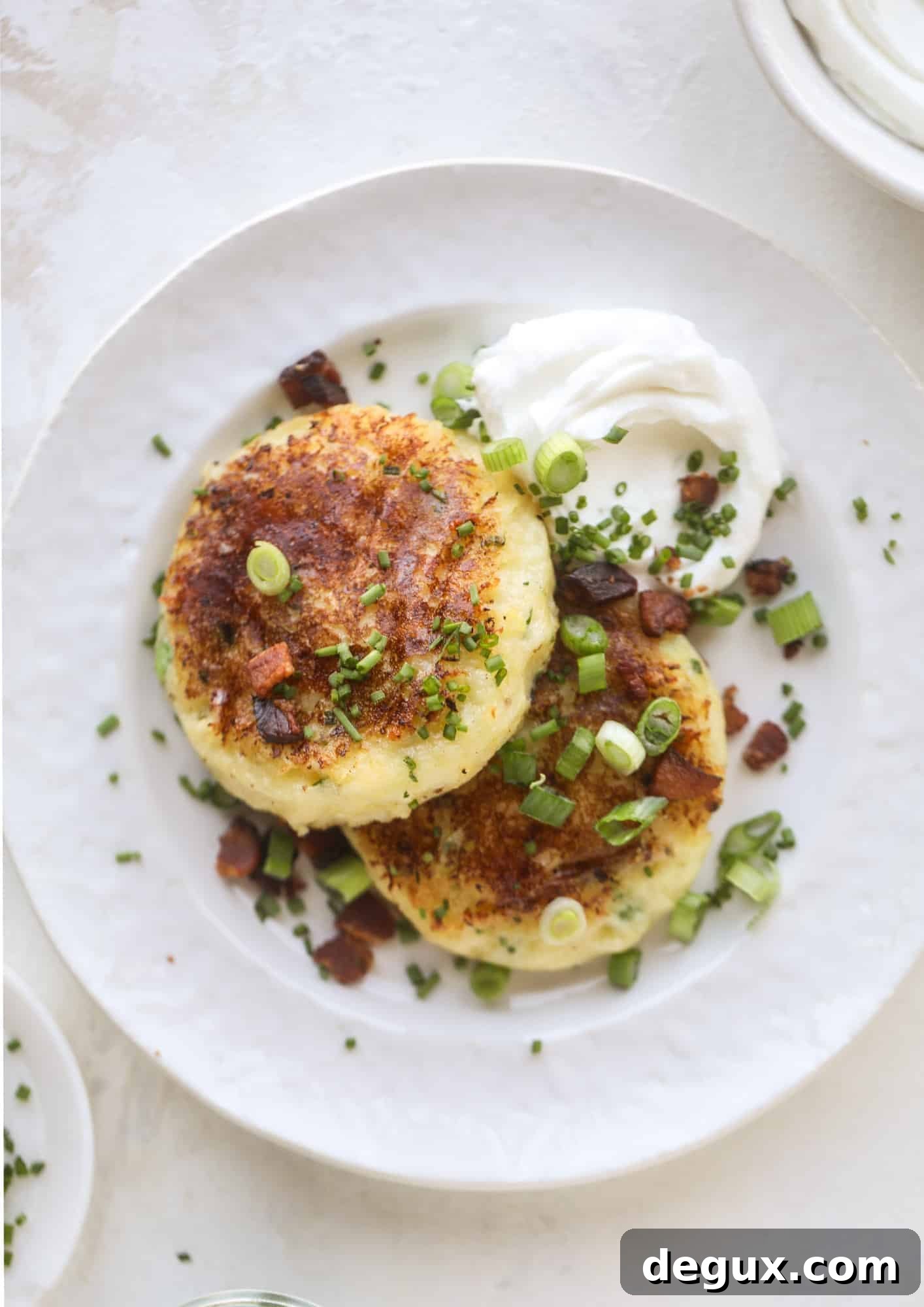 Loaded mashed potato pancakes are the perfect comfort food or side dish to a hearty meat. Crispy mashed potatoes with aged cheddar. Delicious! I howsweeteats.com #mashedpotato #pancakes
