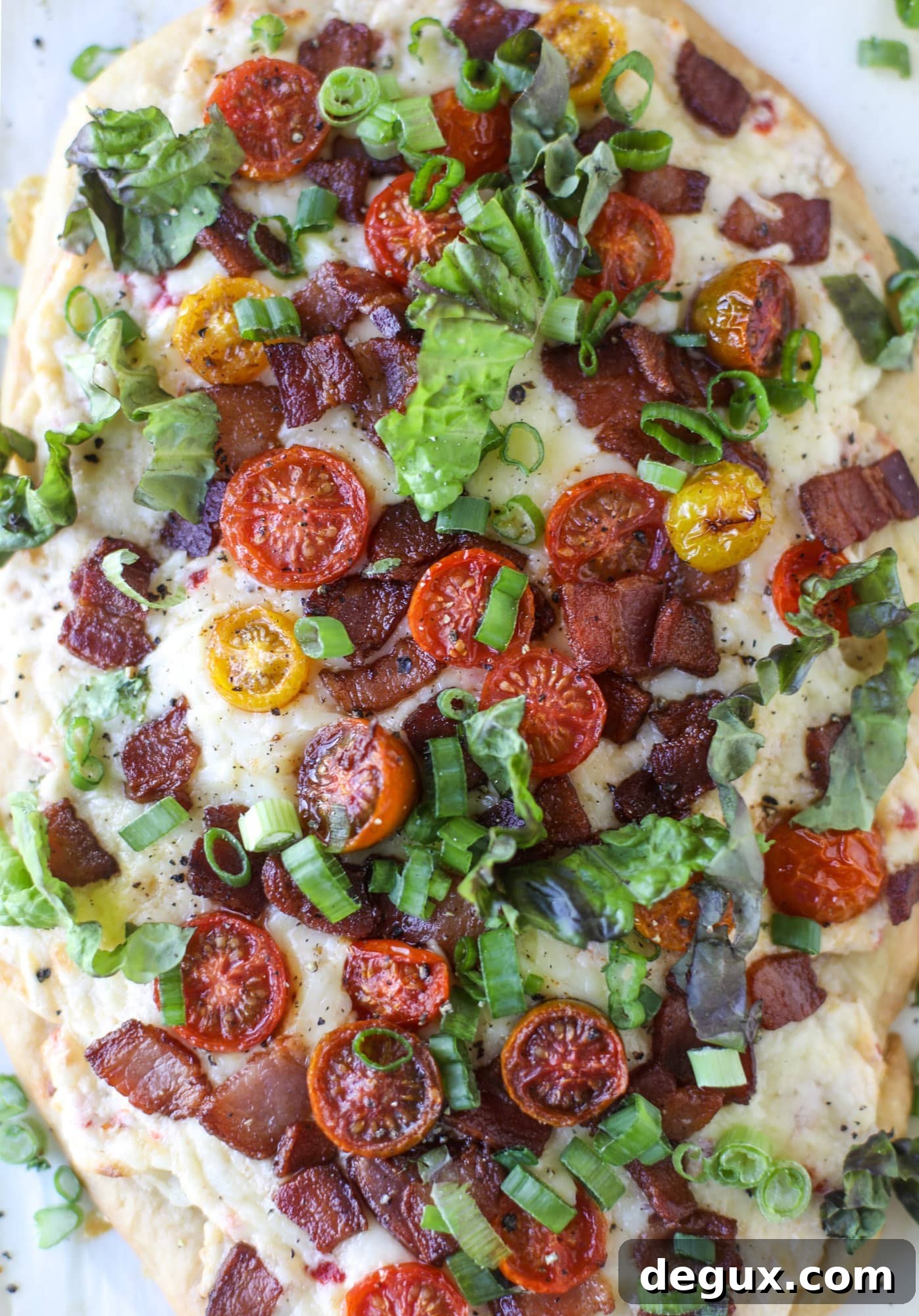 A crisped flatbread crust is topped with creamy pimento cheese, crispy bacon, garlic burst tomatoes and shredded lettuce. It's a flavor explosion!