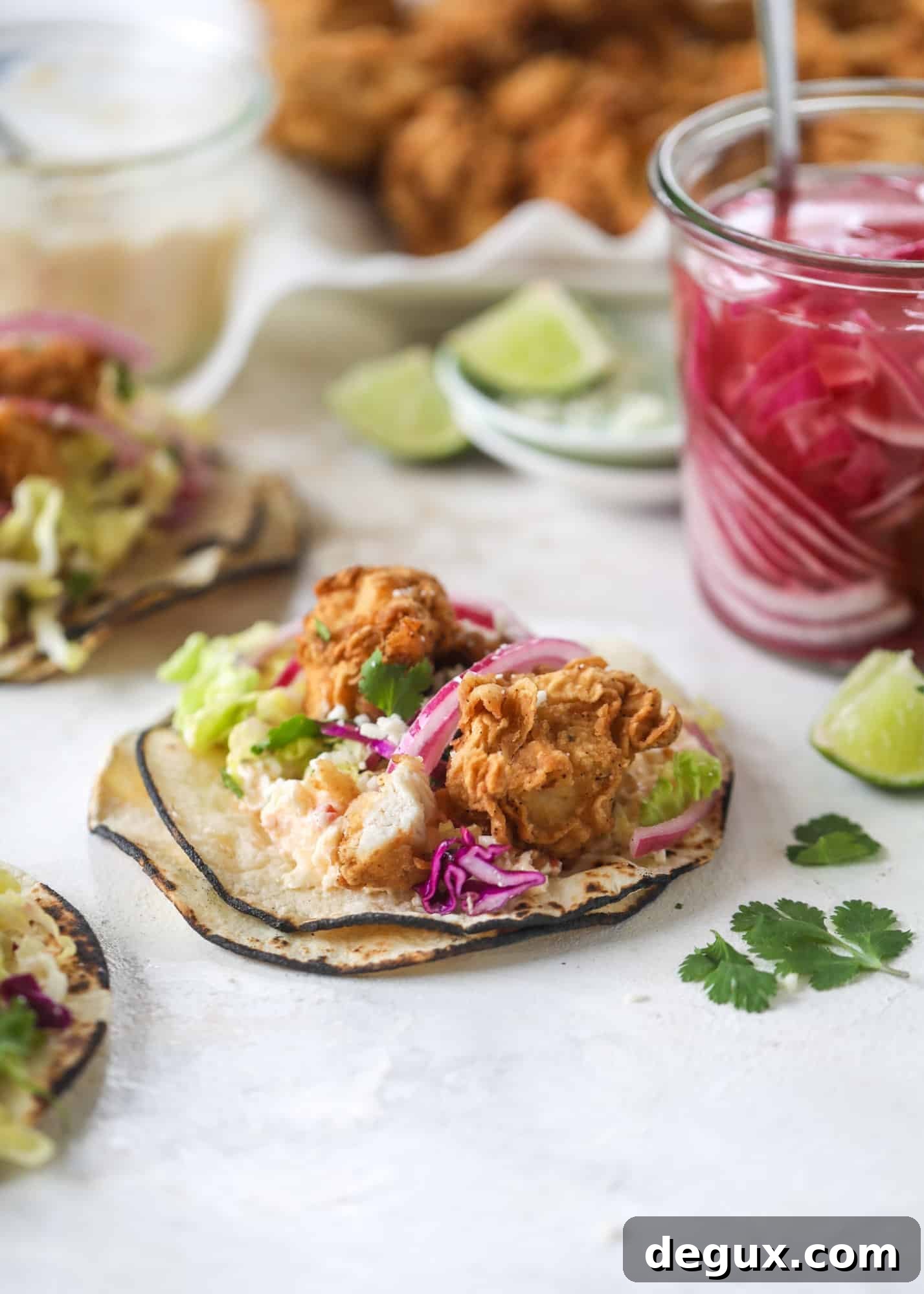 Crispy Chicken Tacos with Gouda and Pimento Cheese 5 Taking crispy chicken tacos to the next level by wrapping them in a warm tortilla with gouda pimento cheese, lime cabbage and pickled onions!