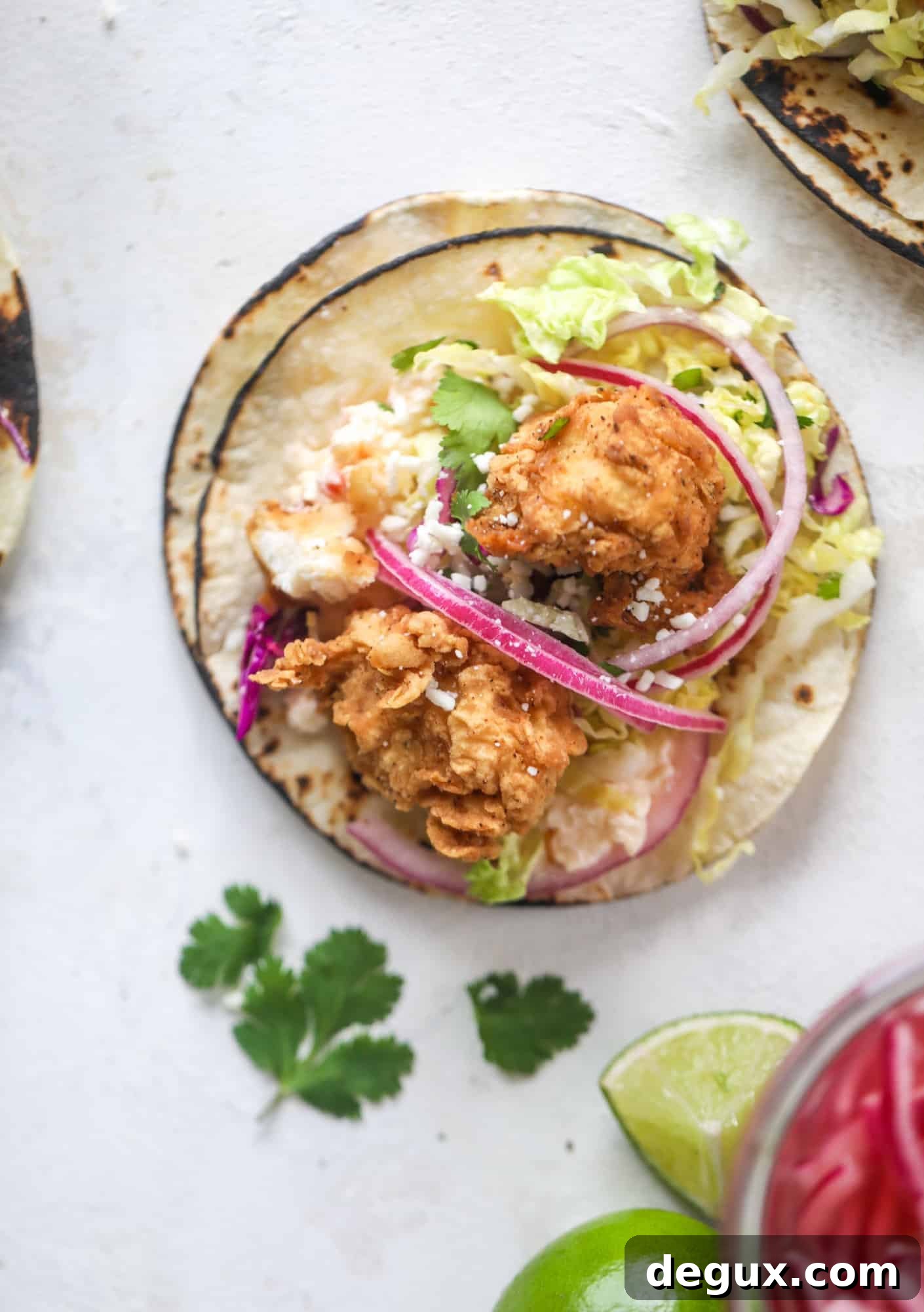 Crispy Chicken Tacos with Gouda and Pimento Cheese 7 Taking crispy chicken tacos to the next level by wrapping them in a warm tortilla with gouda pimento cheese, lime cabbage and pickled onions!