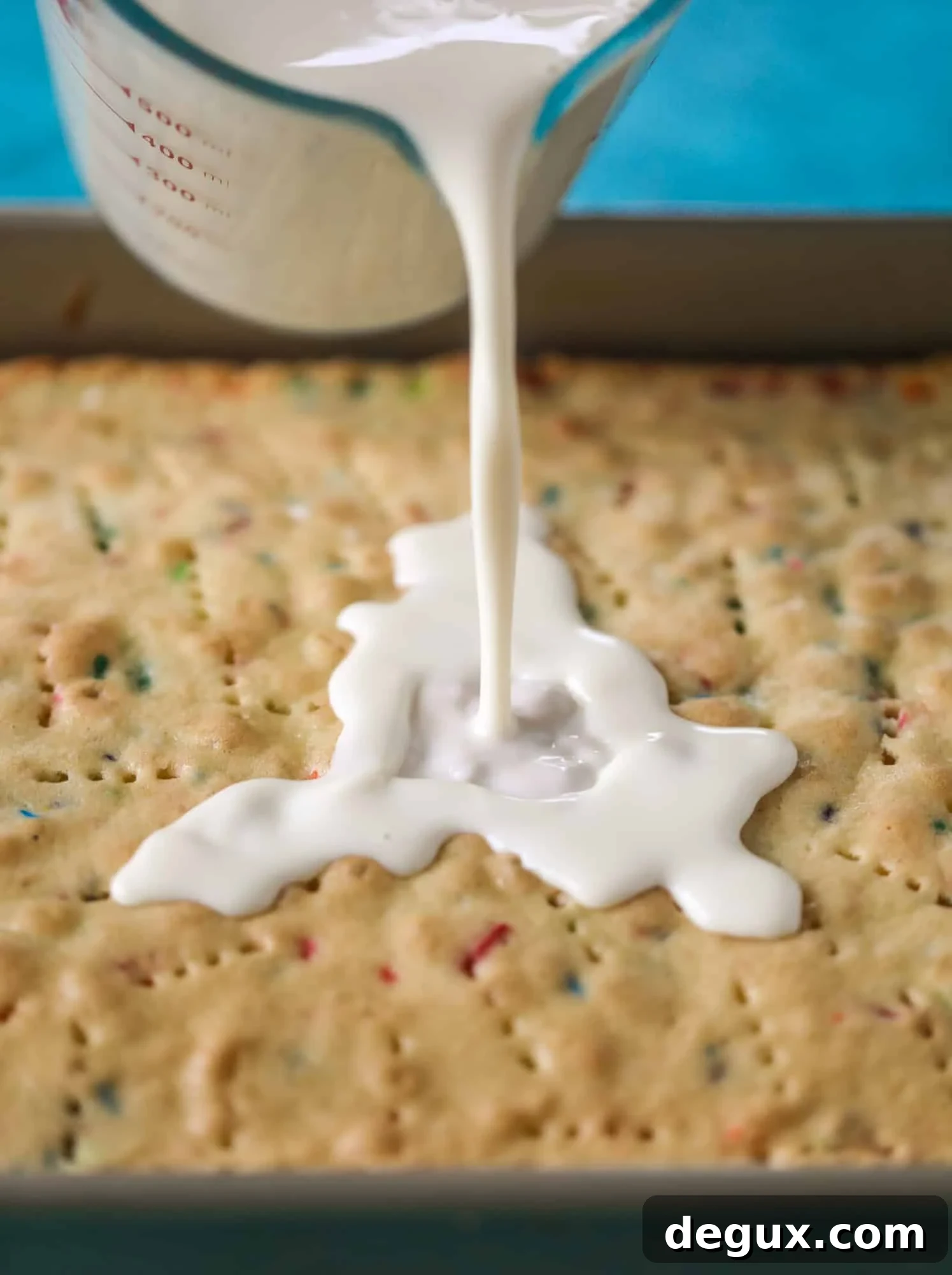 pouring the milks on tres leches cake