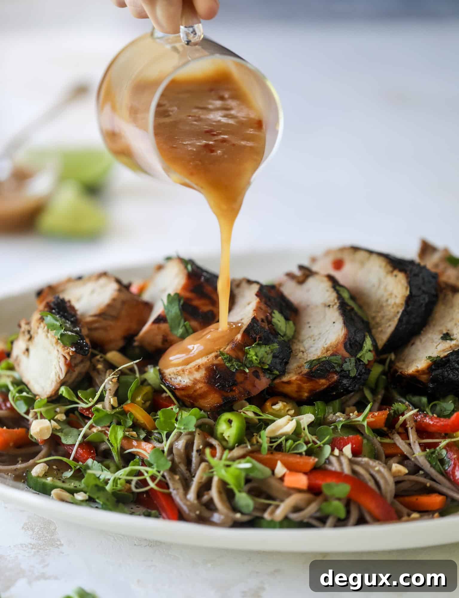 pouring peanut sauce on grilled pork tenderloin