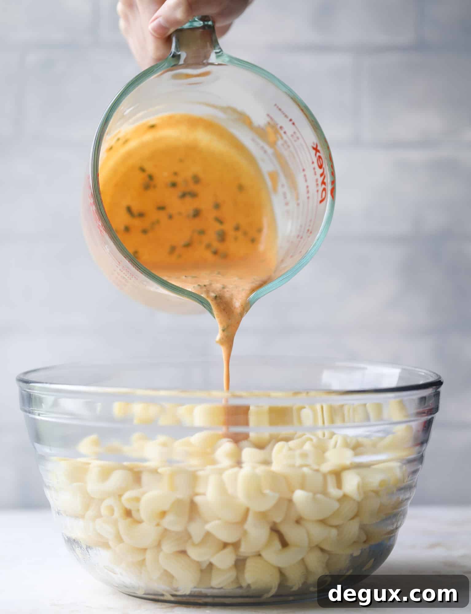 pouring dressing on pasta salad