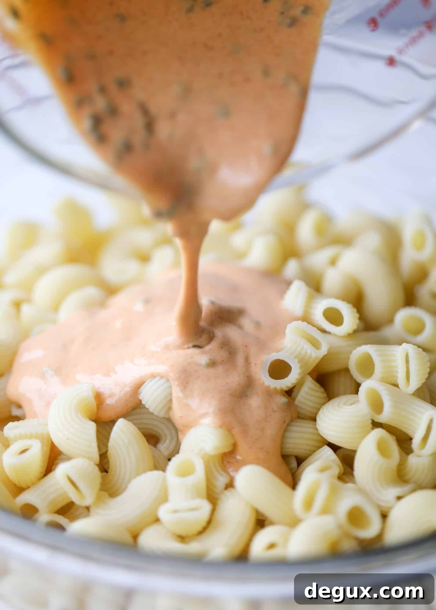 pouring dressing on pasta salad