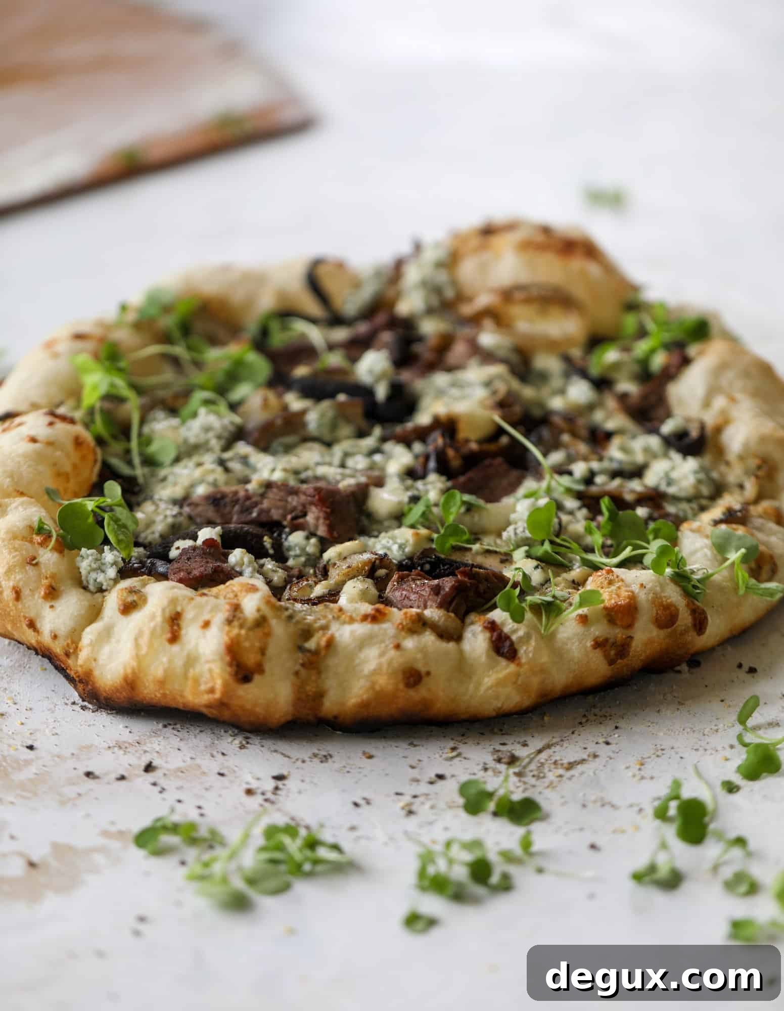 This grilled steakhouse pizza has all the amazing smoky flavors of your favorite steakhouse. Grilled onions, mushrooms and creamy gorgonzola finish it off.