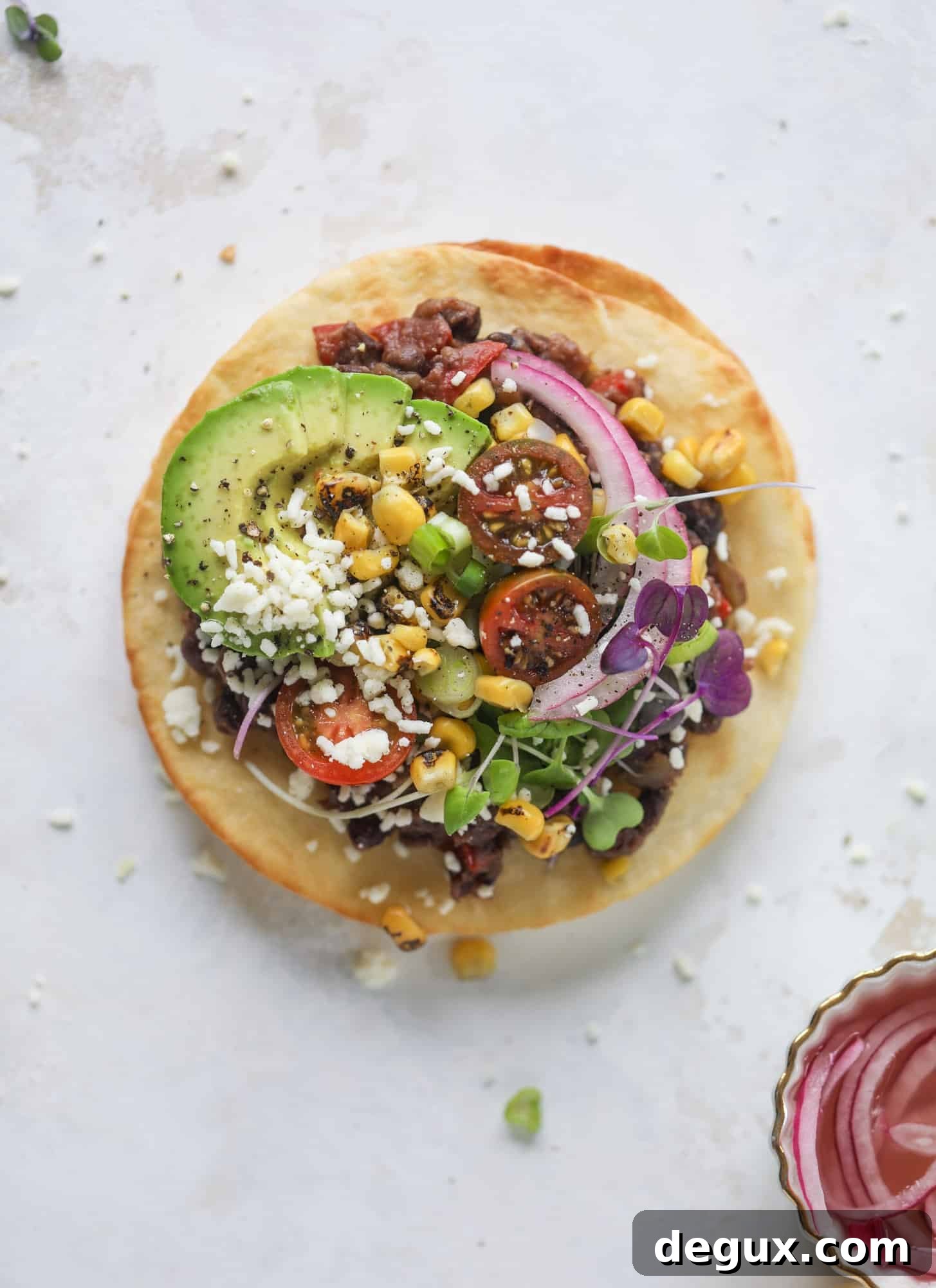These saucy black bean tostadas are super flavorful and easy for a weeknight meal. Crunchy tortillas topped with beans and tons of veggies. Delish!