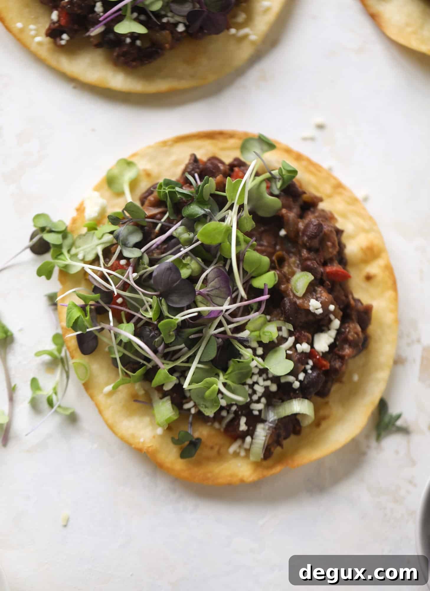 These saucy black bean tostadas are super flavorful and easy for a weeknight meal. Crunchy tortillas topped with beans and tons of veggies. Delish!