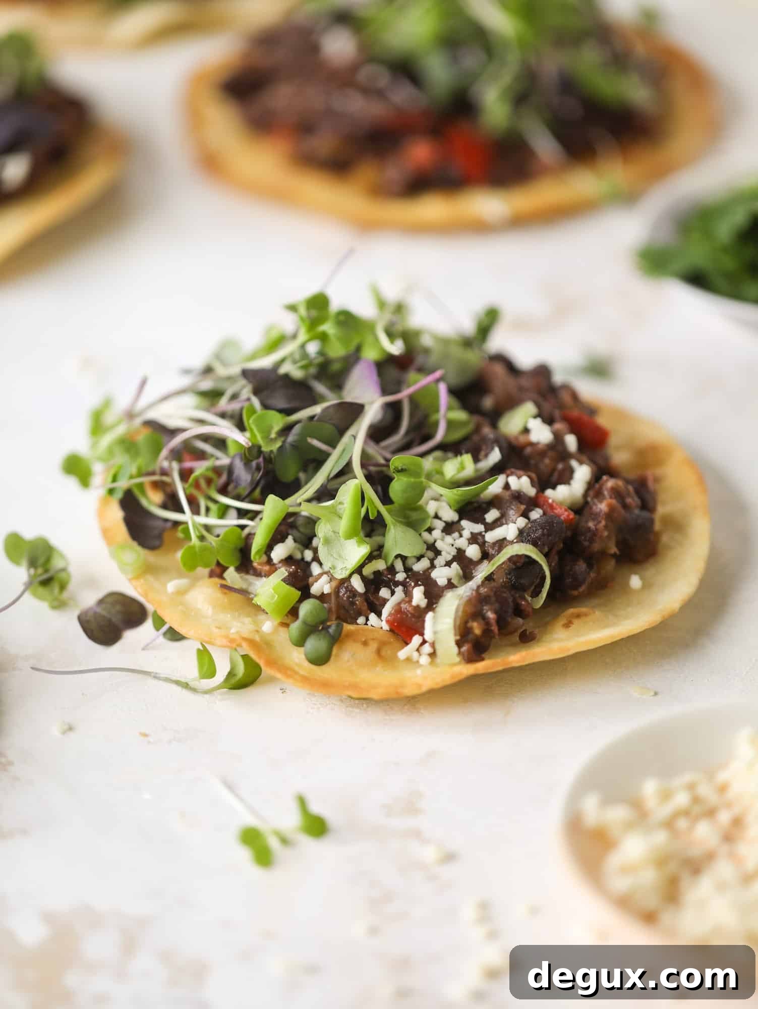 These saucy black bean tostadas are super flavorful and easy for a weeknight meal. Crunchy tortillas topped with beans and tons of veggies. Delish!