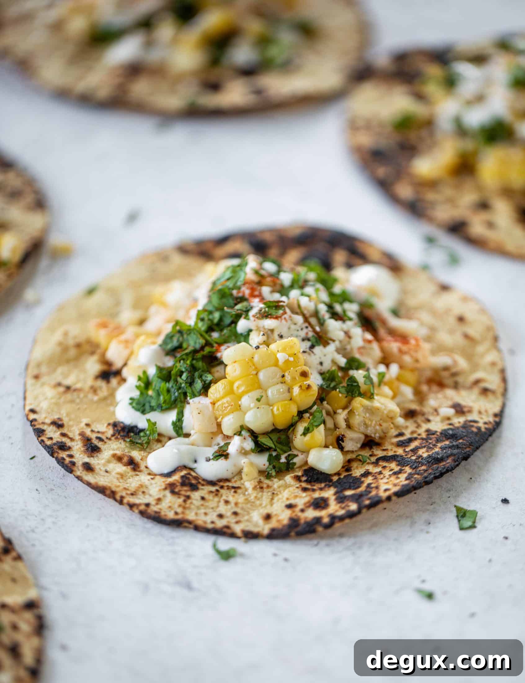 These street corn tacos are filled with a jicama corn salad and drizzled with garlic mayo. This little taco packs a major flavor punch.