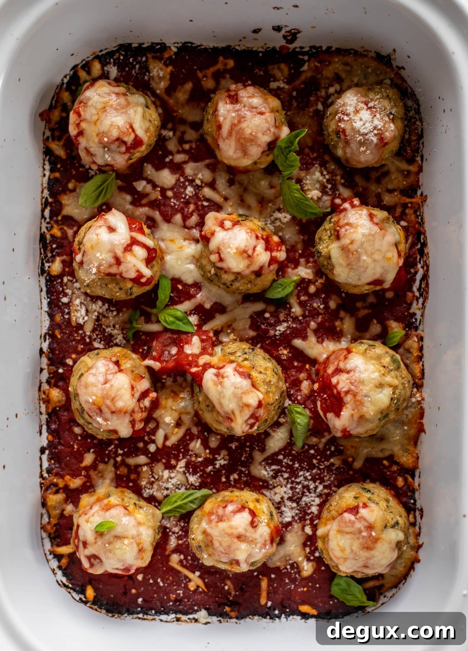 Chicken parmesan meatballs are baked and super flavorful! Serve with roasted garlic spaghetti for the best dinner ever! You can make them ahead of time too!