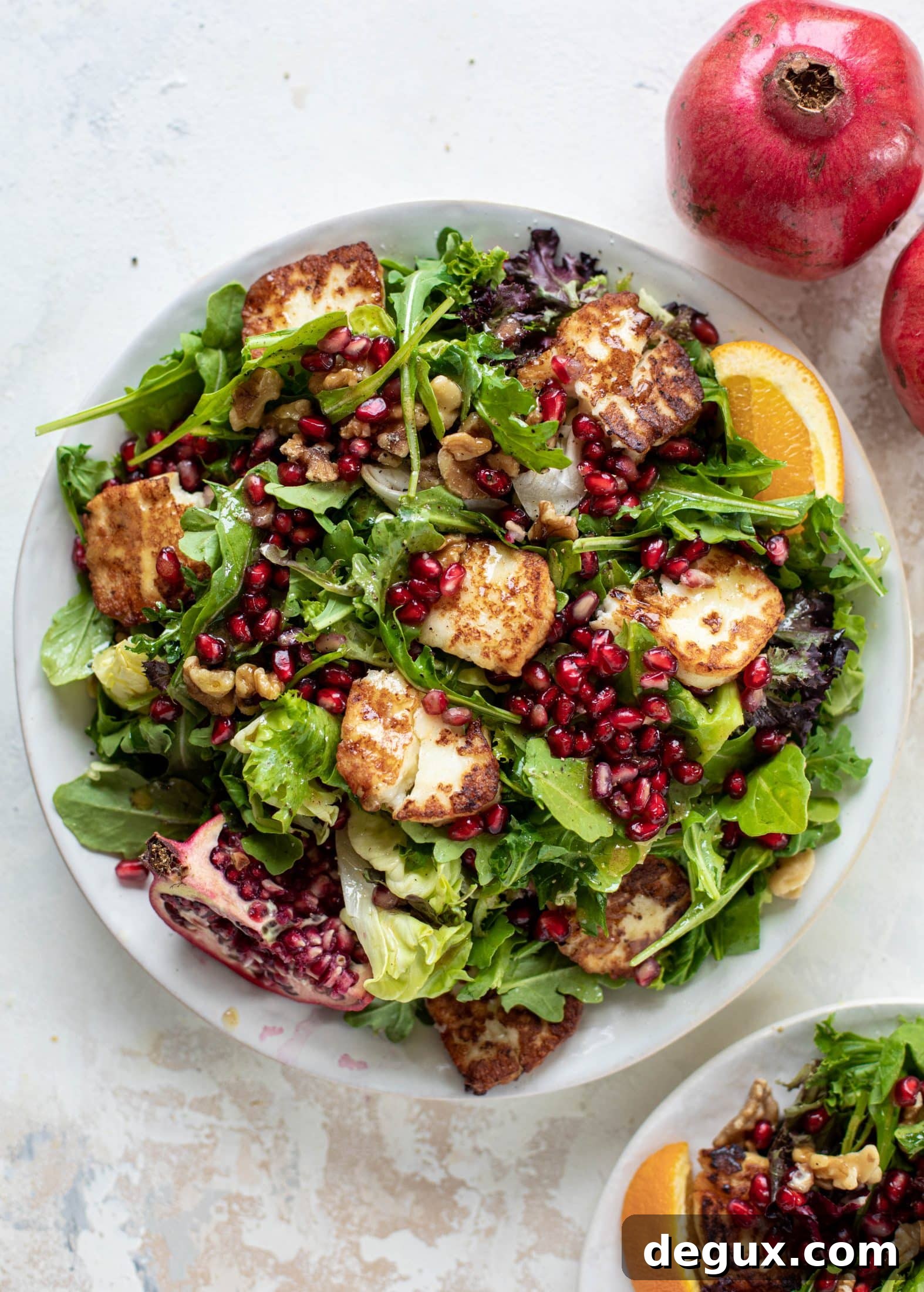 A pomegranate halloumi salad that's the perfect starter to your holiday meal! Drizzle with a spiced orange vinaigrette for the most festive flavor ever.