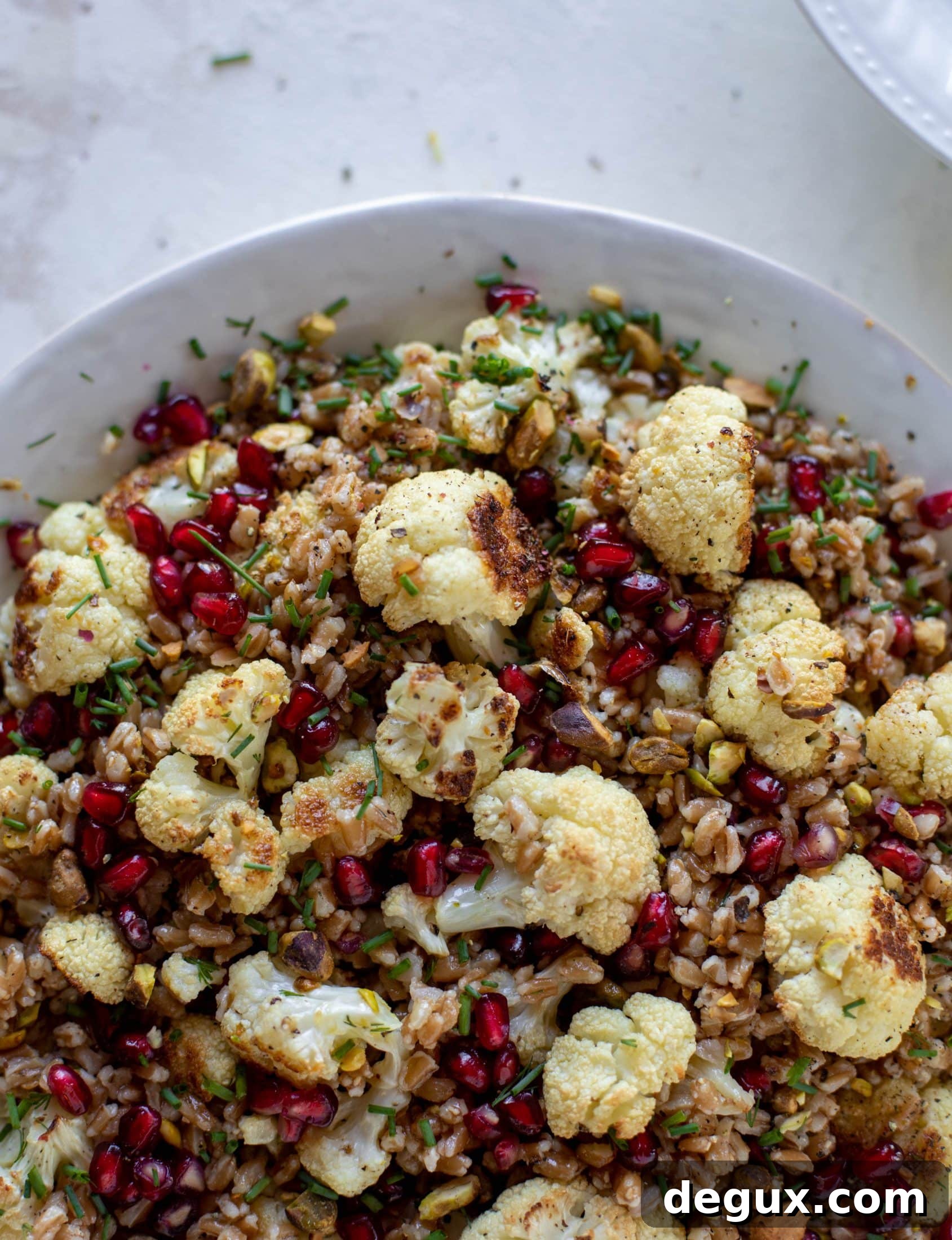 This cauliflower farro salad is filled with roasted cauliflower, pistachios, pomegranates and drizzled with a dill vinaigrette. Delicious!
