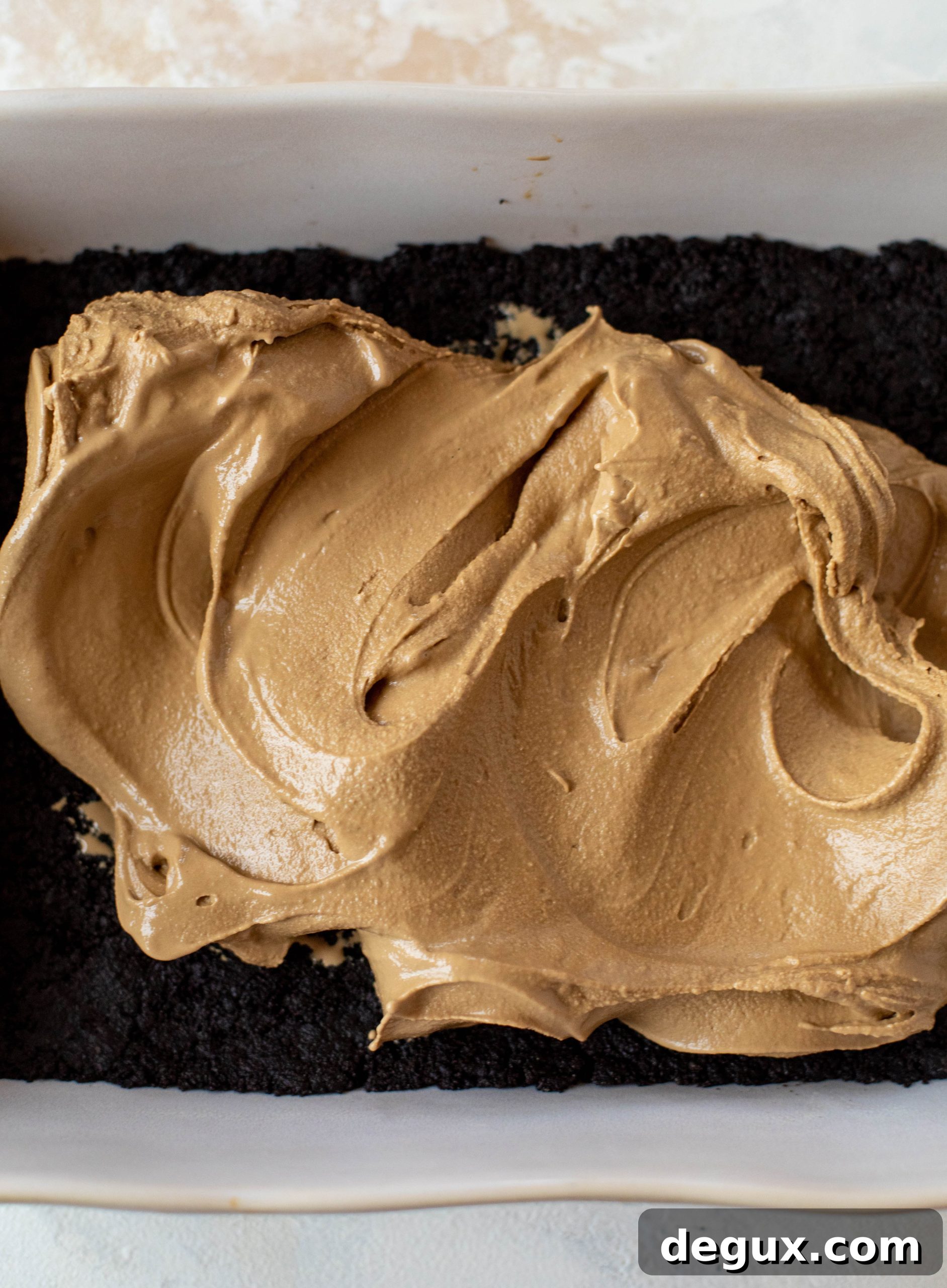 This frozen chocolate cookie dessert is a twist on the classic 90s recipe! Cookie crust, ice cream, homemade hot fudge and whipped cream. It's amazing!