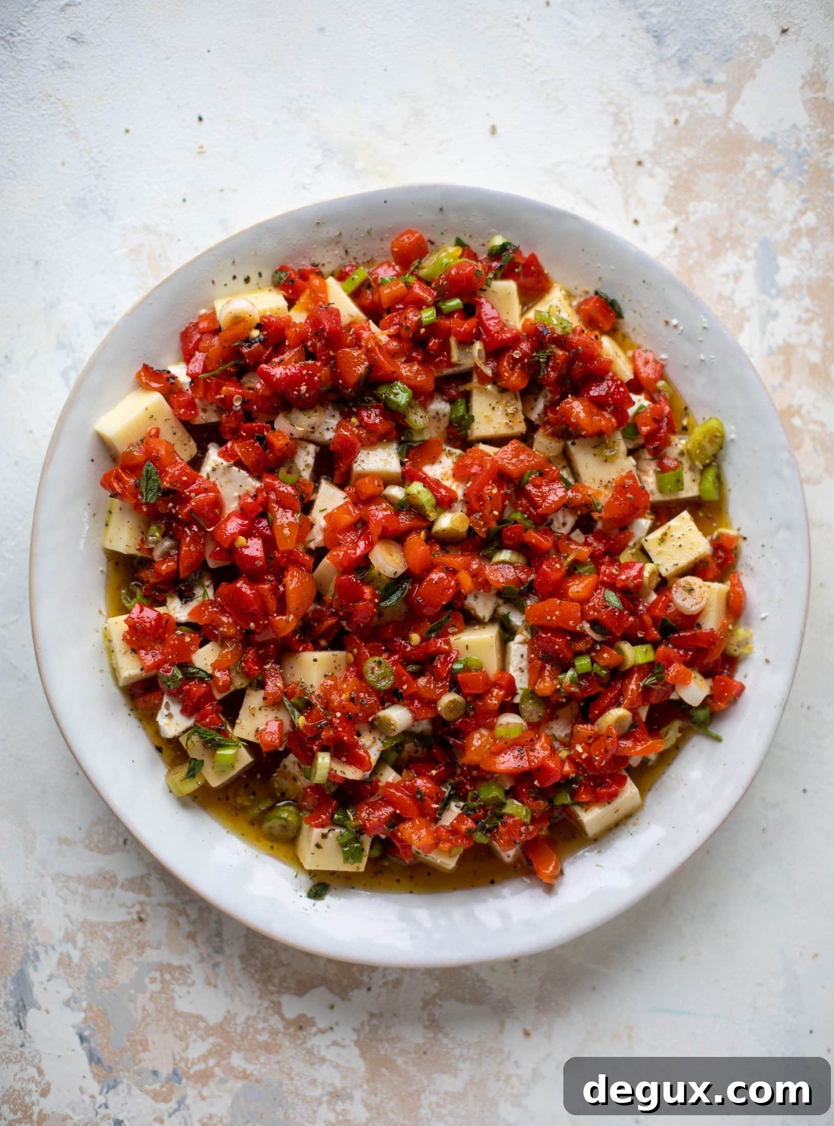 This marinated cheese recipe is perfect for Christmas! Make it ahead and transport it easily to your destination. It's absolutely delicious.