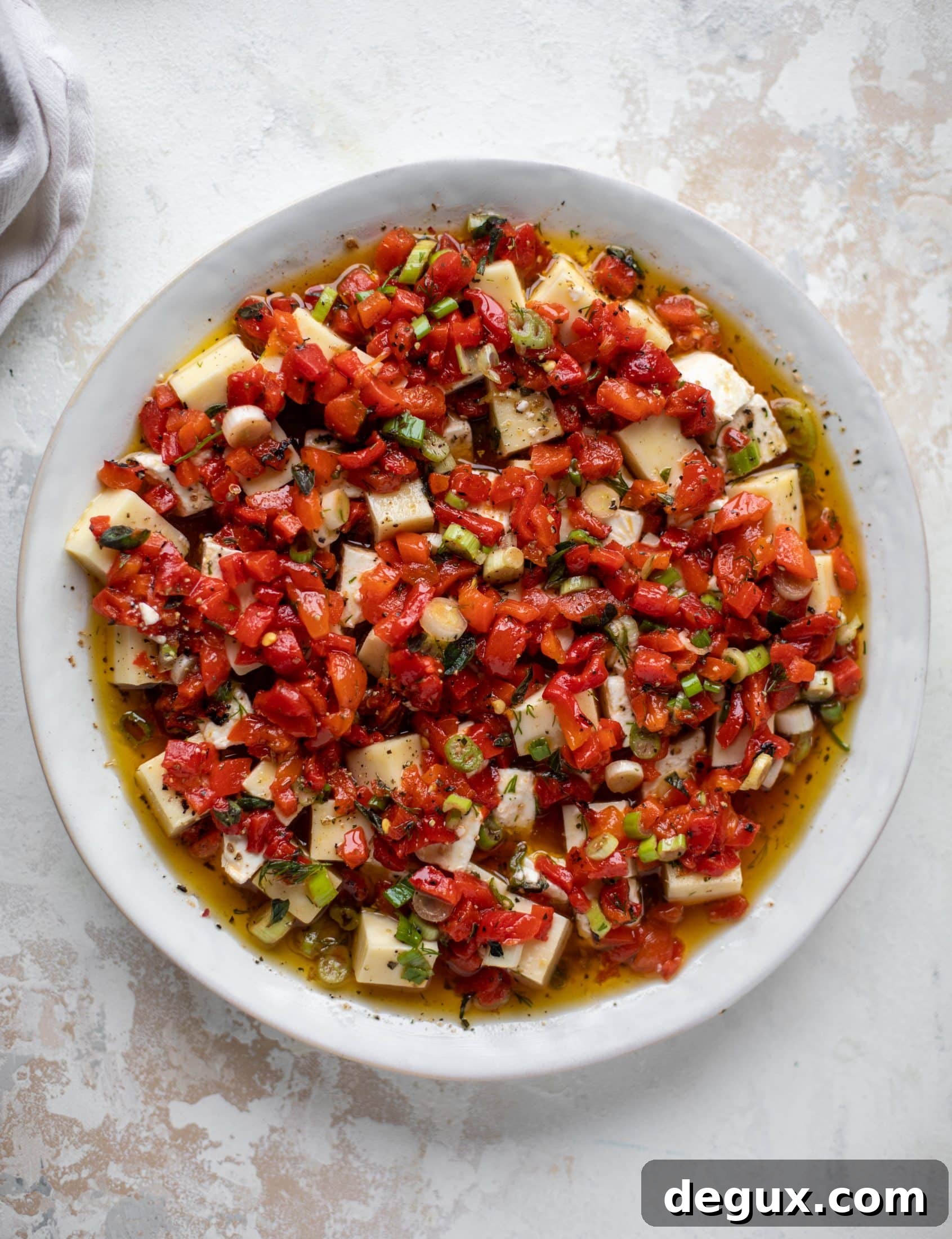 This marinated cheese recipe is perfect for Christmas! Make it ahead and transport it easily to your destination. It's absolutely delicious.