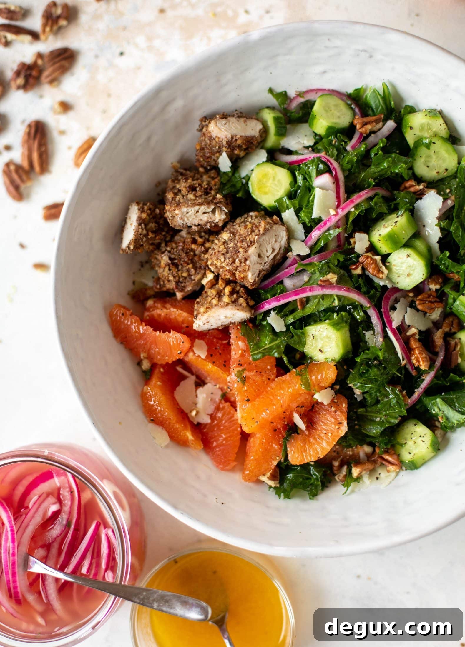 This pecan crusted chicken salad is so hearty! Kale, cara cara oranges, pickled onions, cucumbers and pecorino make this a bowl of flavor.