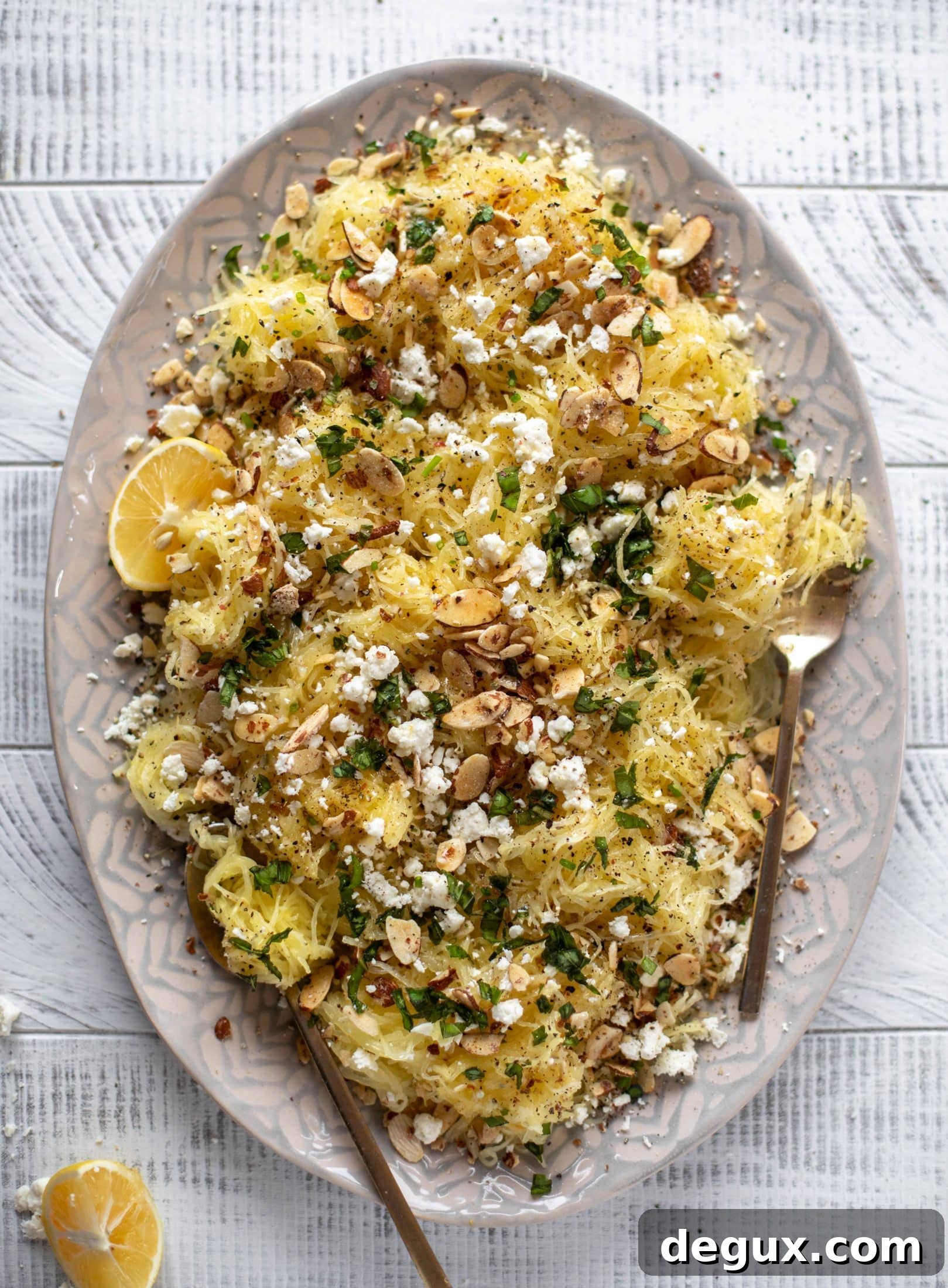 This lemon spaghetti squash is tossed in a lemon garlic butter and topped with feta, sliced toasted almonds and fresh herbs. It's delicious! 