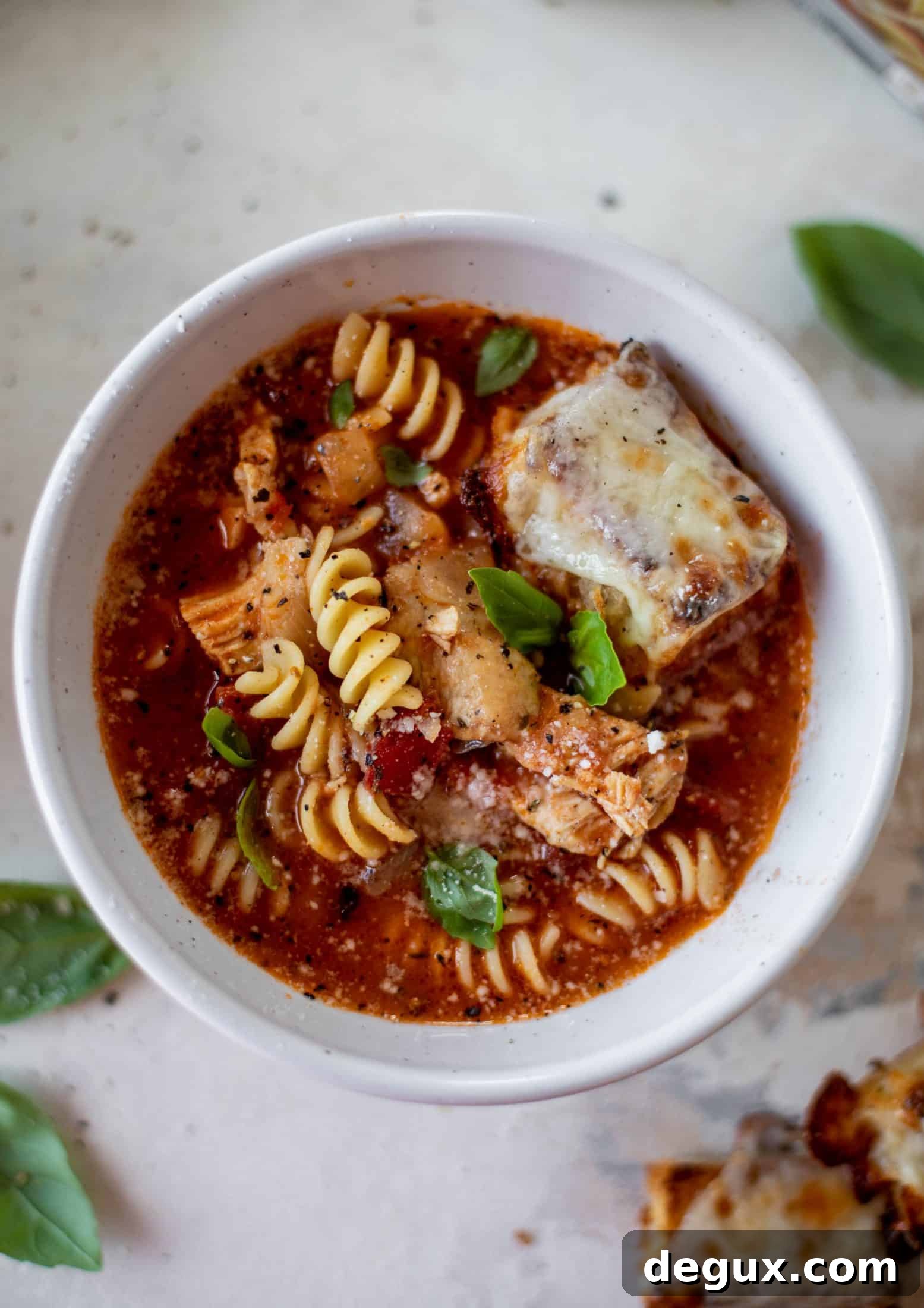 This chicken parmesan soup is ridiculously flavorful and so easy to make! Juicy chicken with pasta, fire roasted tomatoes and mozzarella croutons.
