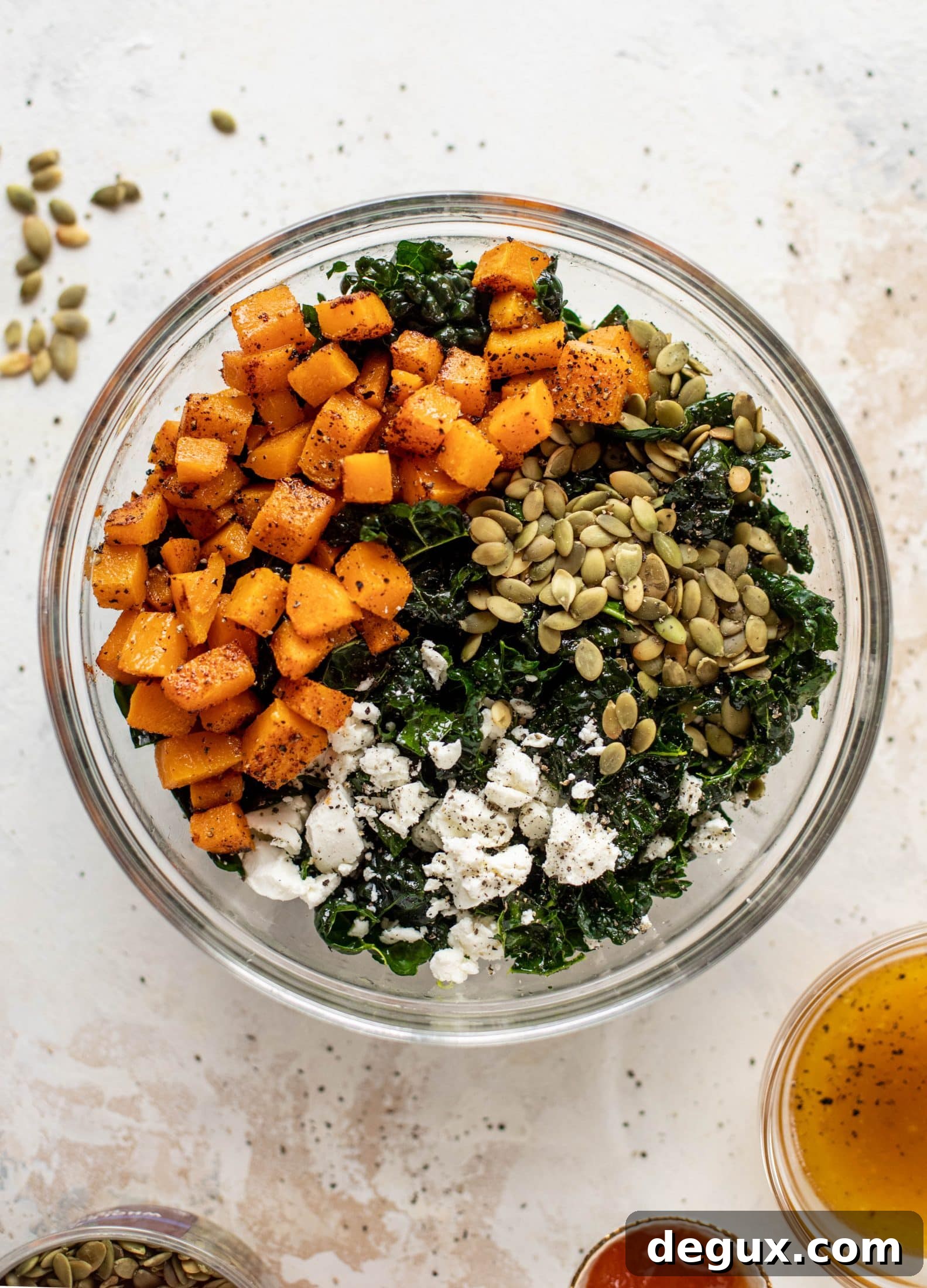 This butternut squash kale salad is so easy and delicious! Roasted, smoky butternut squash, goat cheese, pepitas and apricot vinaigrette.