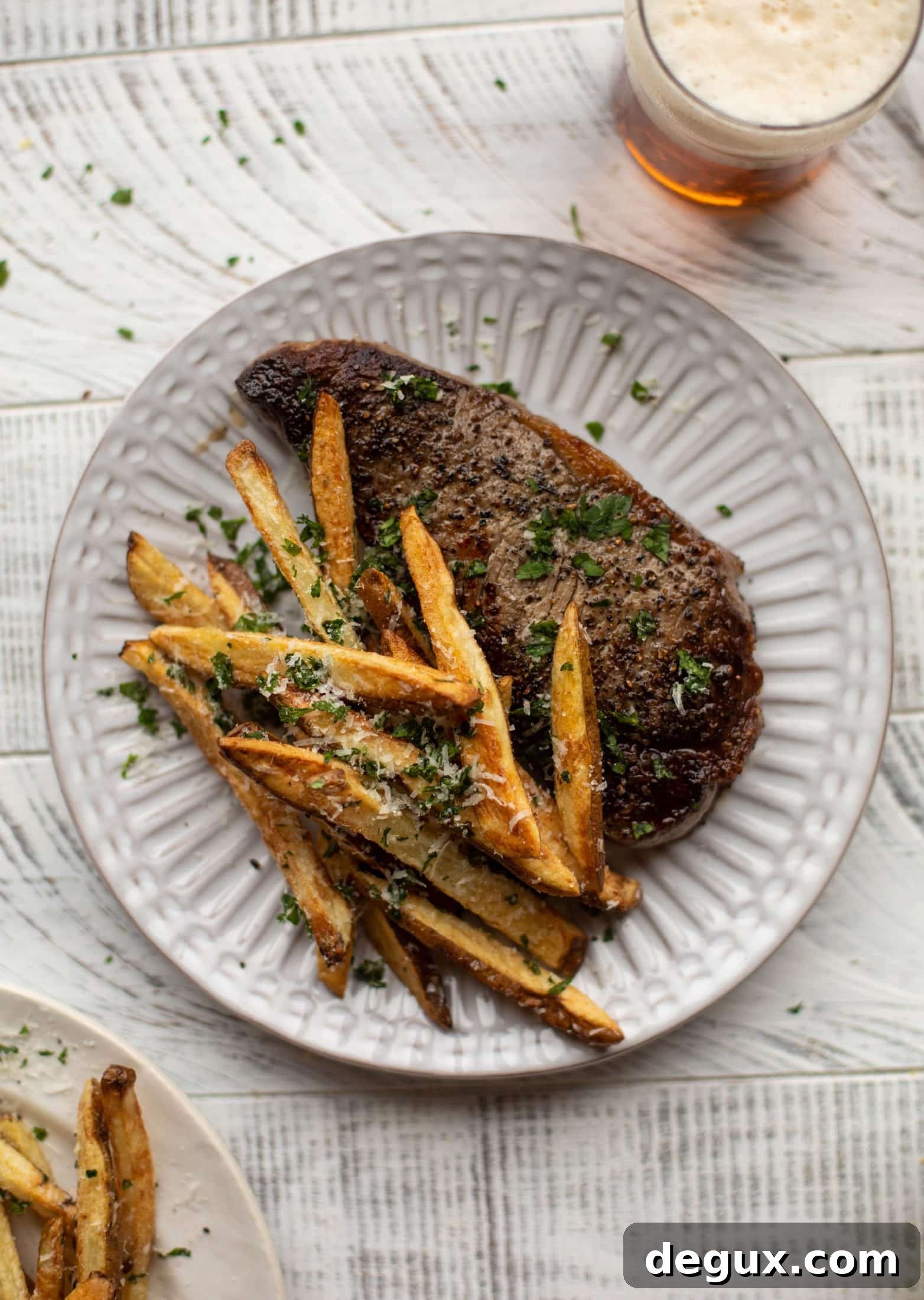 This is our favorite steak frites! Seared skillet steak and crispy fries made in the air fryer, topped with truffle salt, parmesan and herbs!