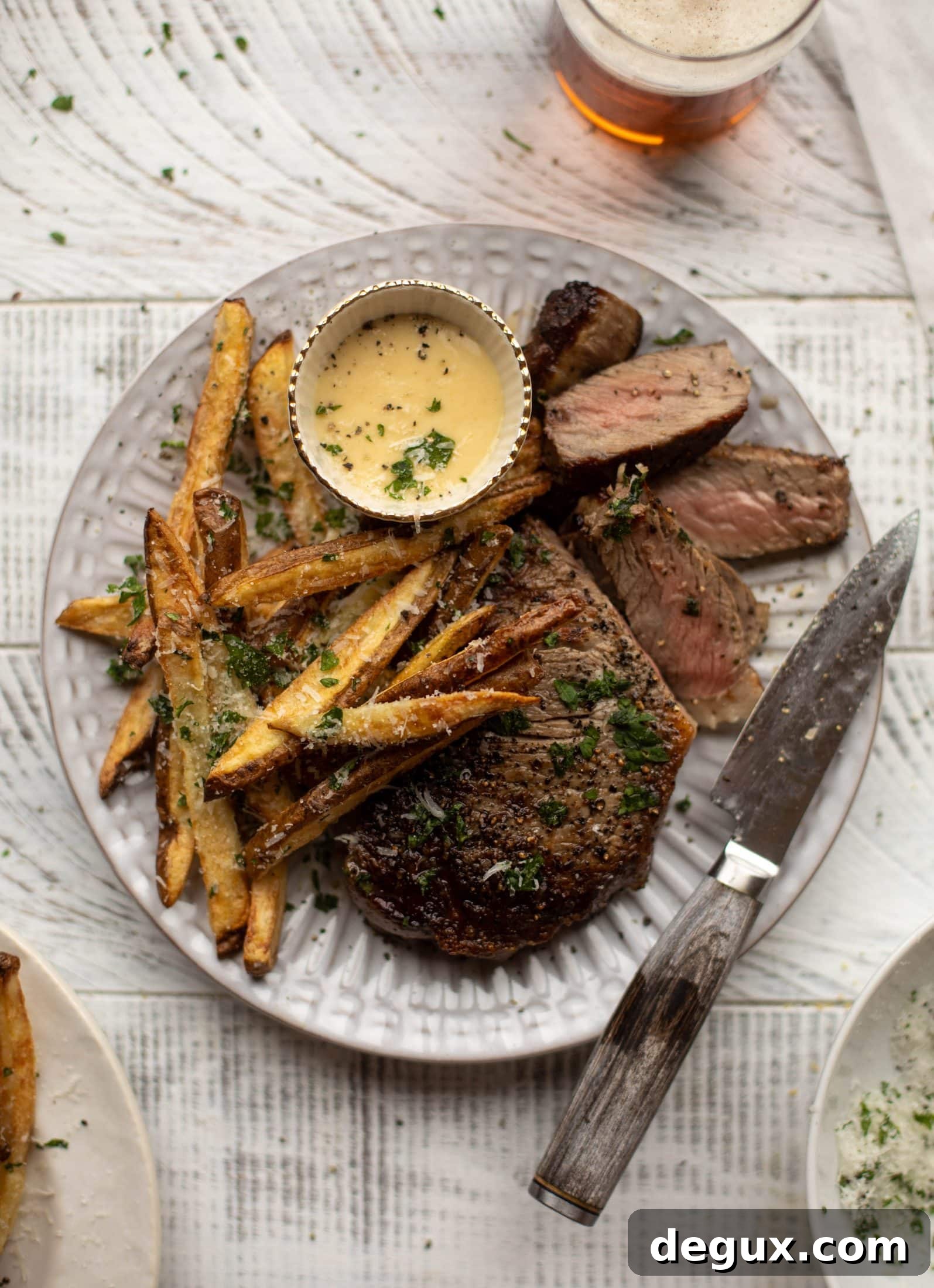 This is our favorite steak frites! Seared skillet steak and crispy fries made in the air fryer, topped with truffle salt, parmesan and herbs!