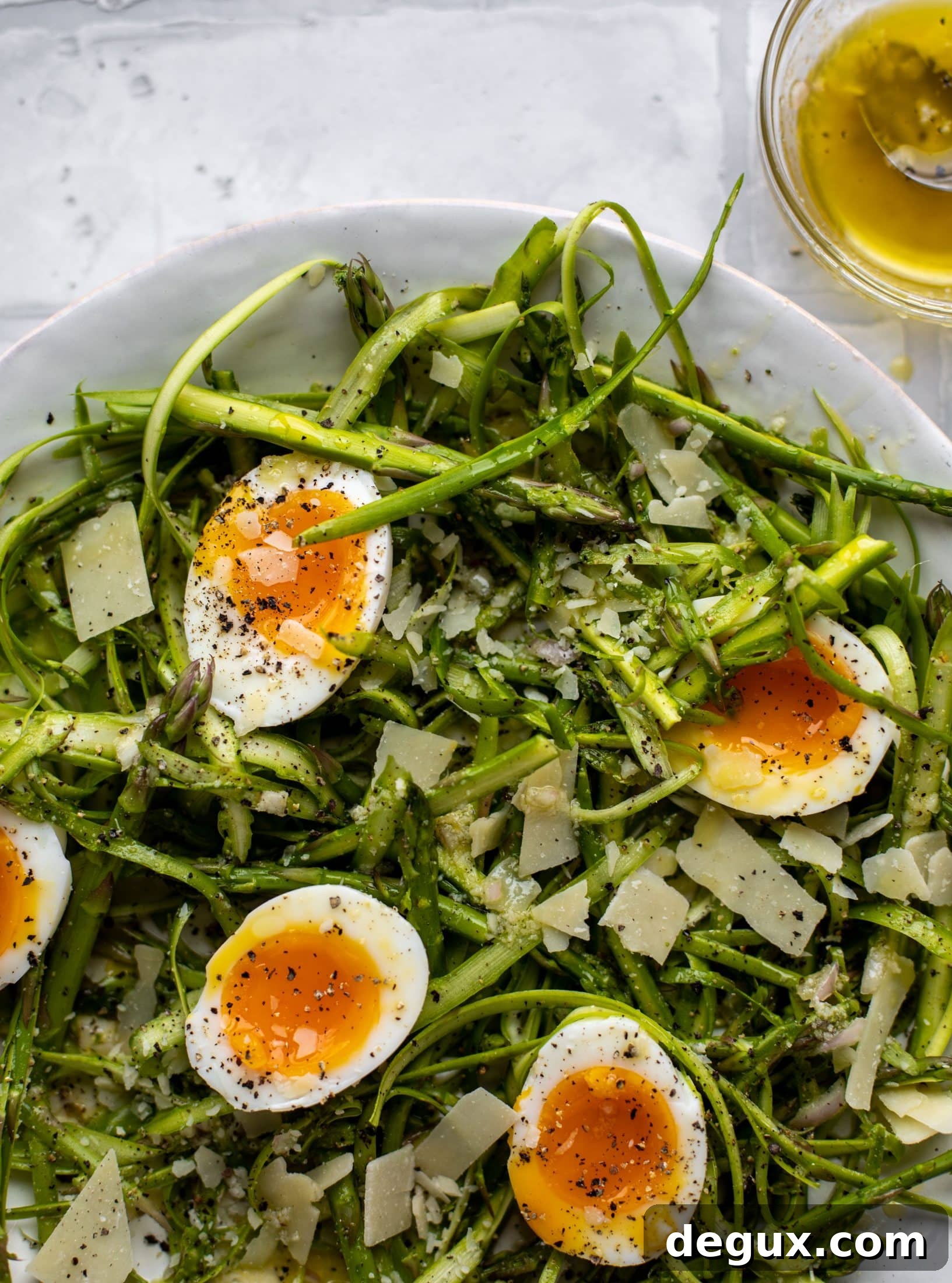 This shaved asparagus salad is tossed with a delicious parmesan vinaigrette, then topped with soft boiled eggs and finished with crunchy garlic breadcrumbs!