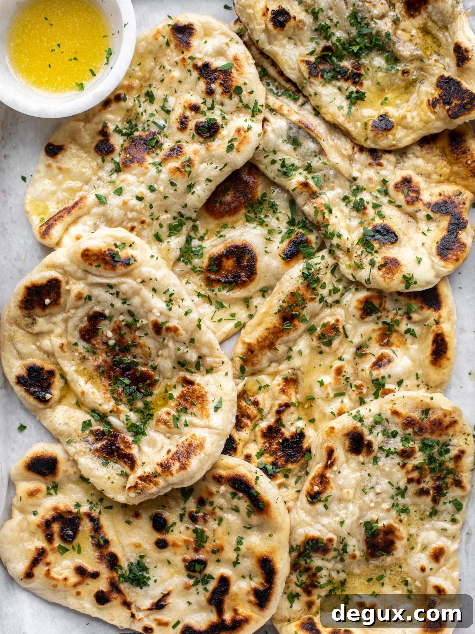 This garlic butter naan bread recipe is divine! It uses baking powder and baking soda instead of yeast and is drenched with garlic butter. So delicious!