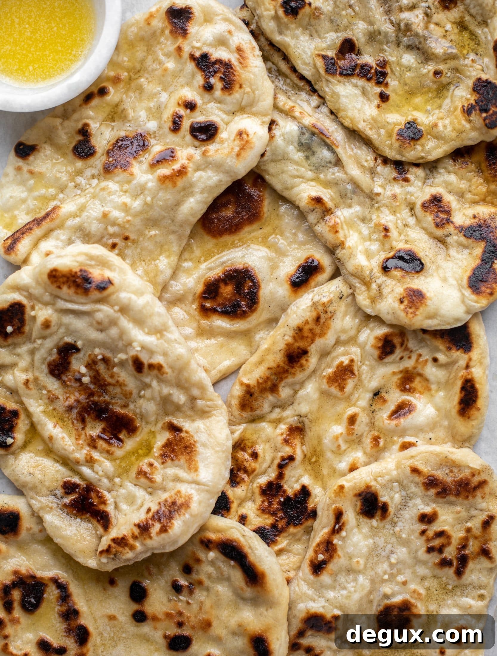 This garlic butter naan bread recipe is divine! It uses baking powder and baking soda instead of yeast and is drenched with garlic butter. So delicious!
