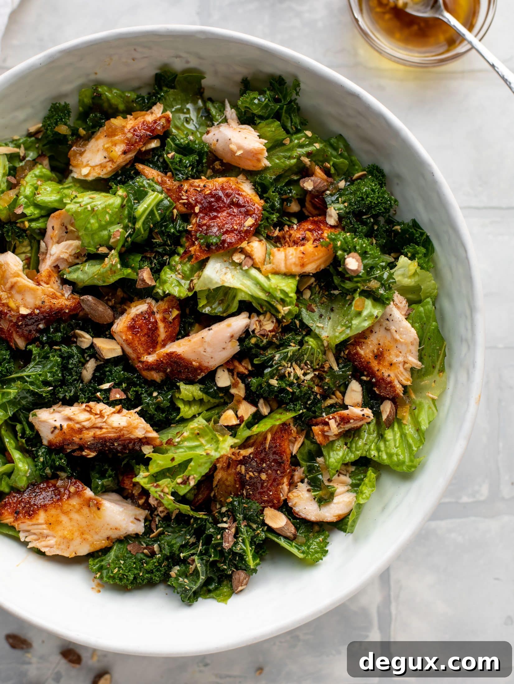 This ginger salmon salad has the flaky, flavorful roasted salmon on top of kale and romaine, drizzled with warm ginger vinaigrette.